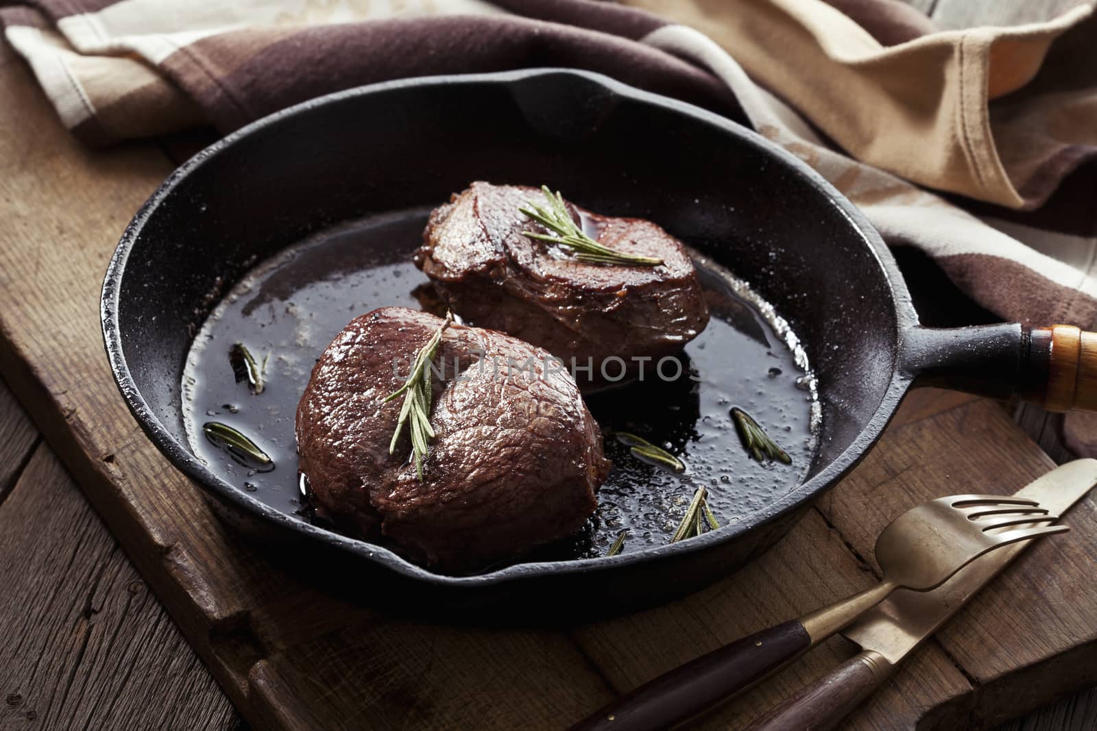 Beef steak in pan on wooden background