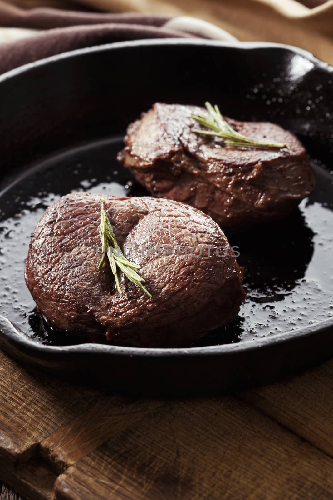 Beef steak in pan on wooden background