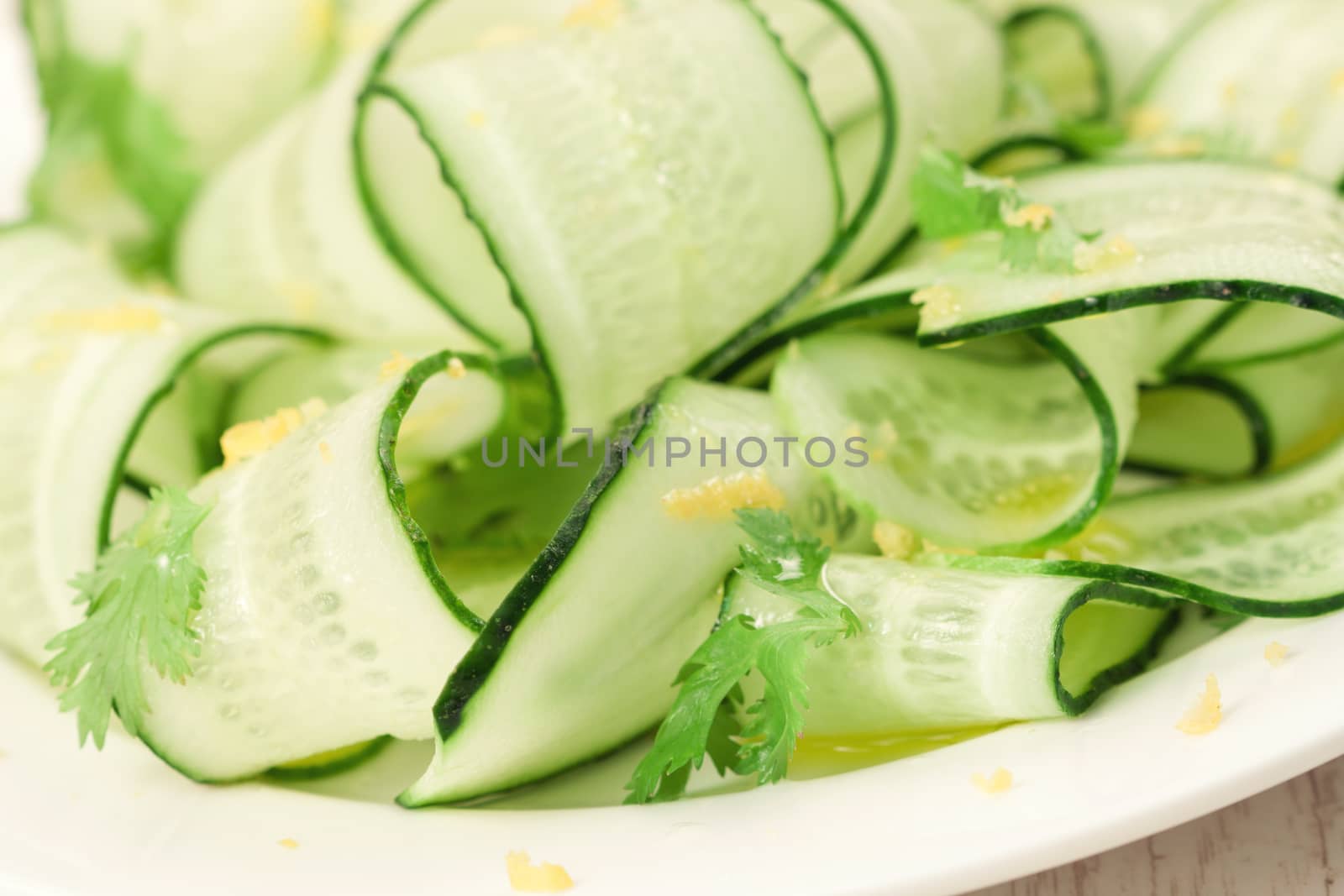 Sliced green cucumbers salad with cilantro