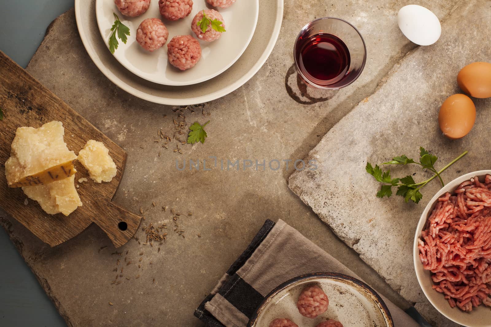 Meatballs cooking with mince, parsley, parmesan, wine and eggs.