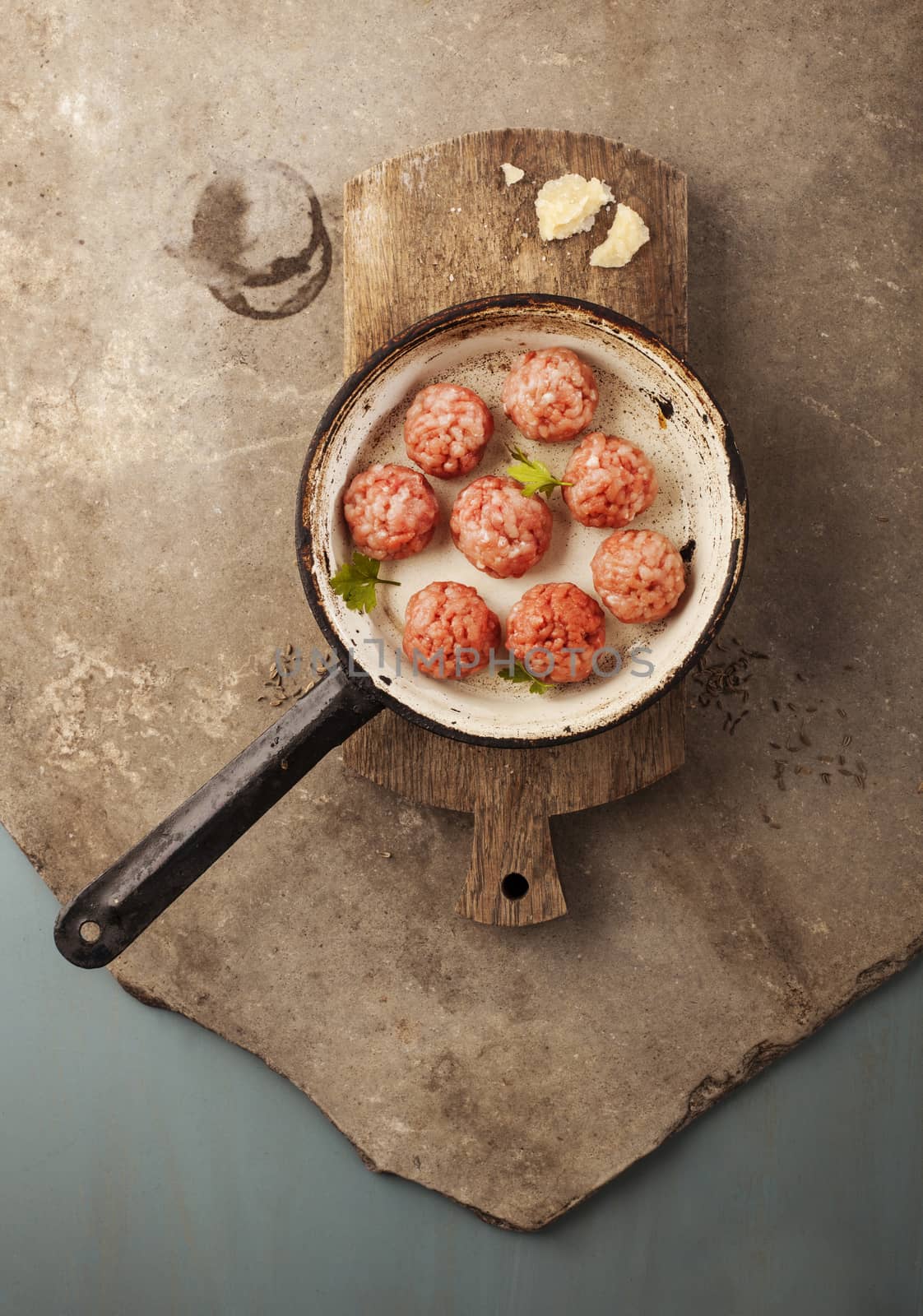 Meatballs cooking with mince, parsley, parmesan, wine and eggs.