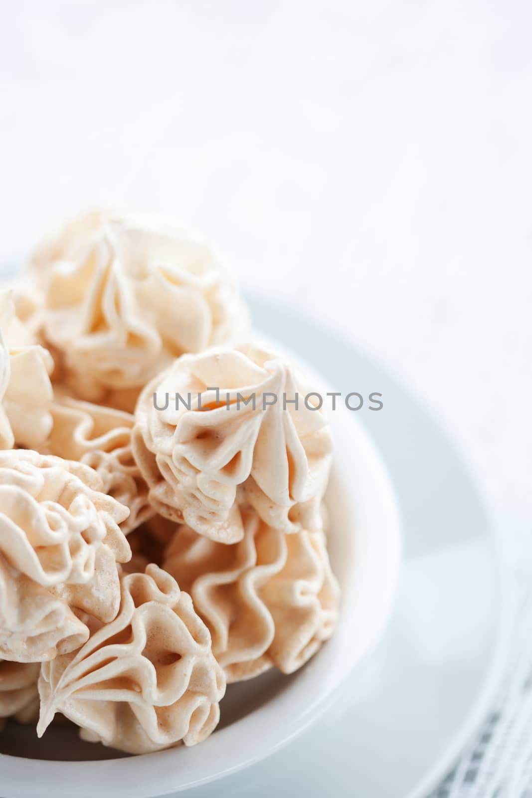 Meringues on white tablecloth, shallow dof.