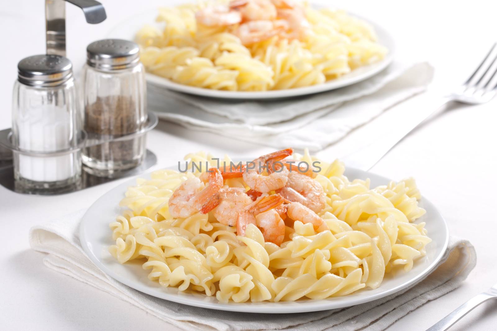 Two plates of pasta with shrimps