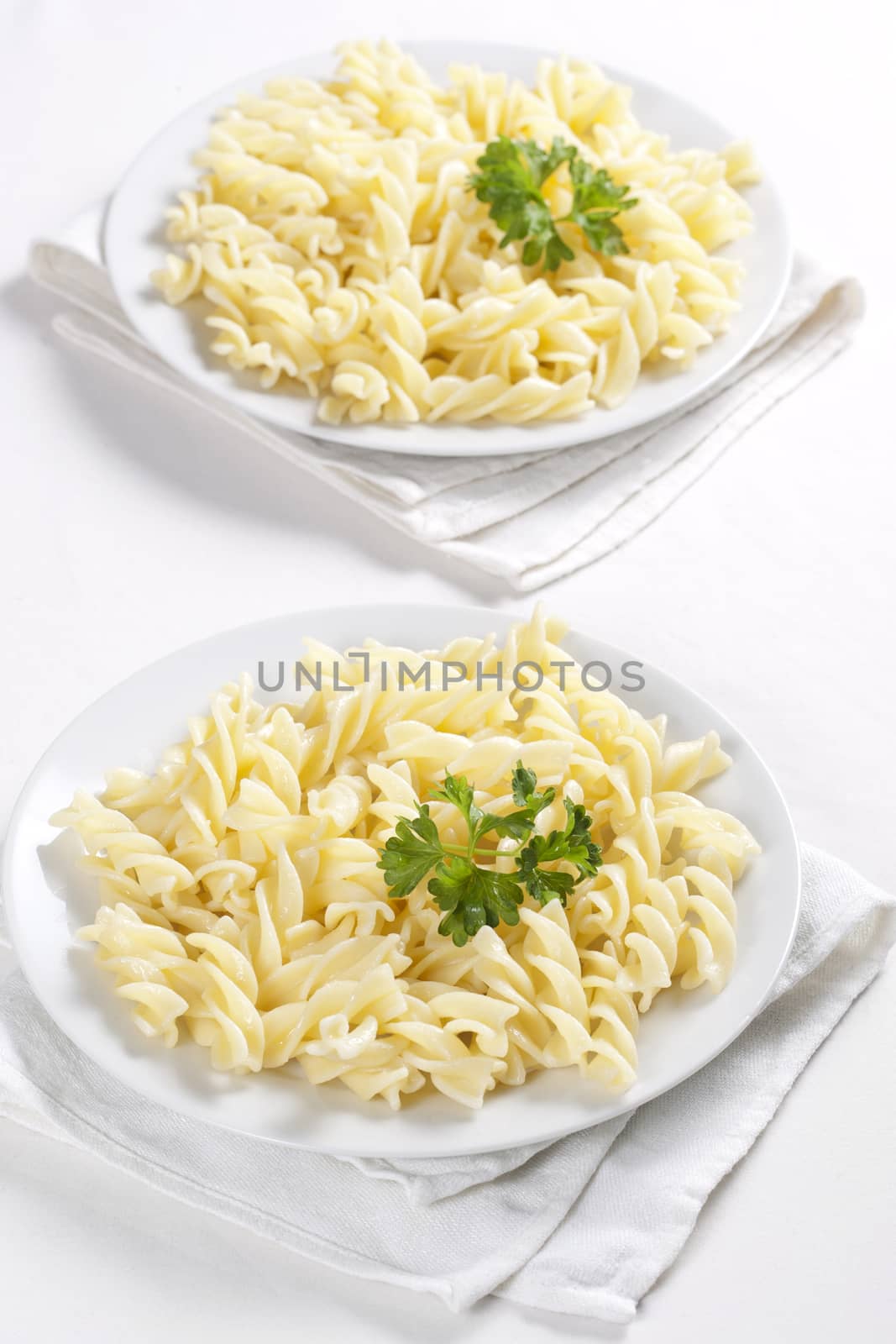 Two plates of pasta with parsley