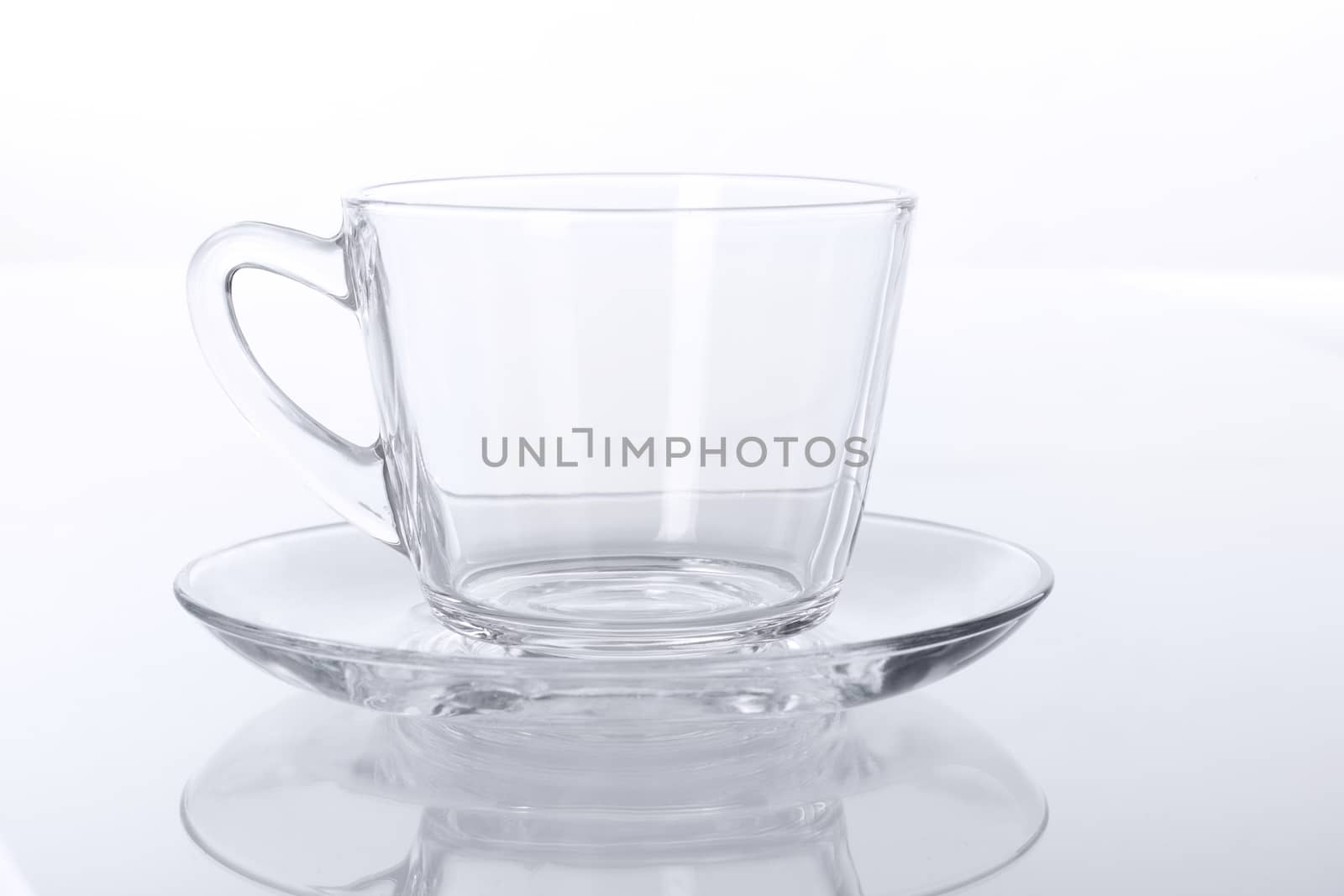 Empty transparent glass cup and saucer.