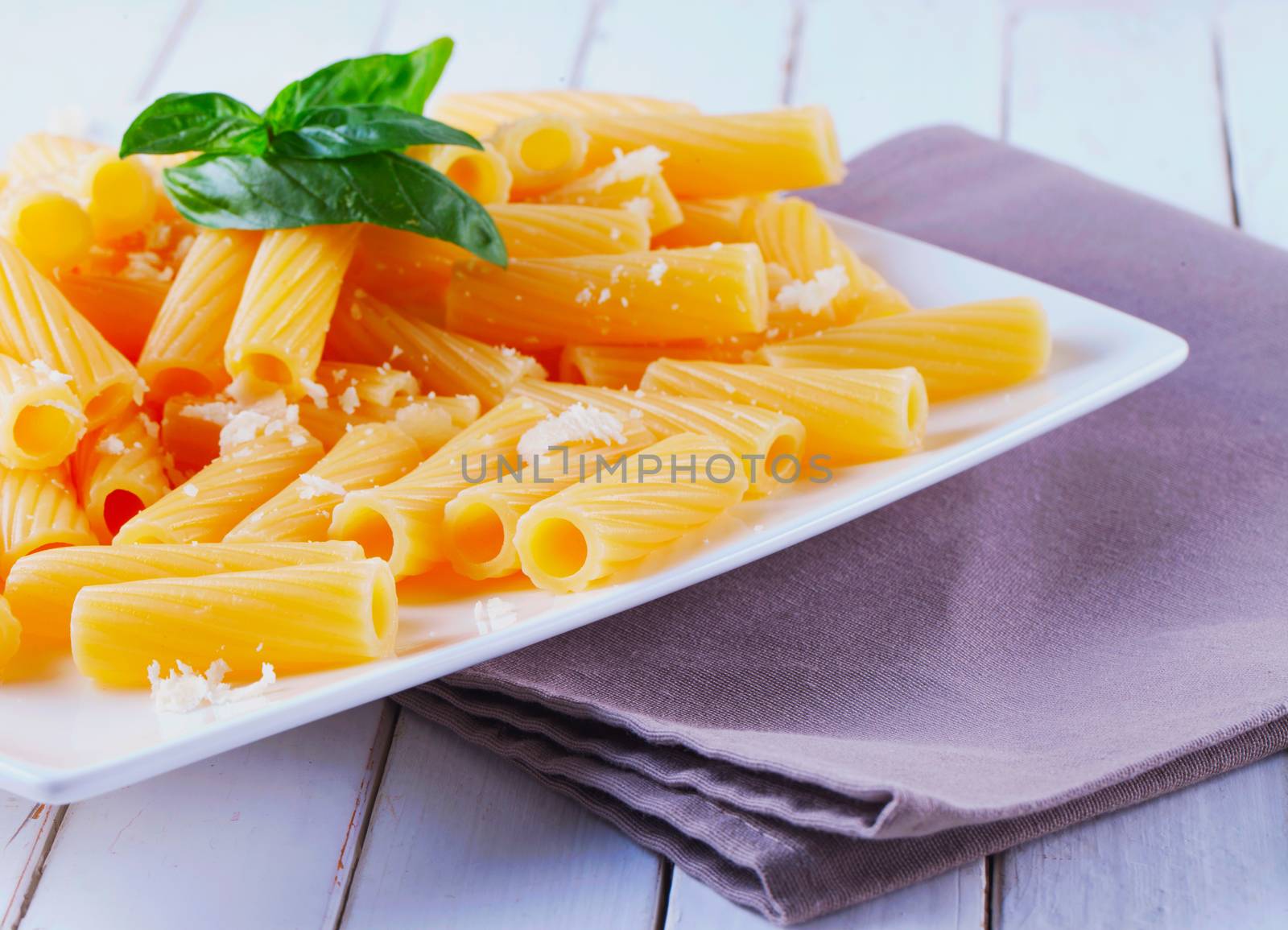 Pasta with parmesan and basil, over white plate