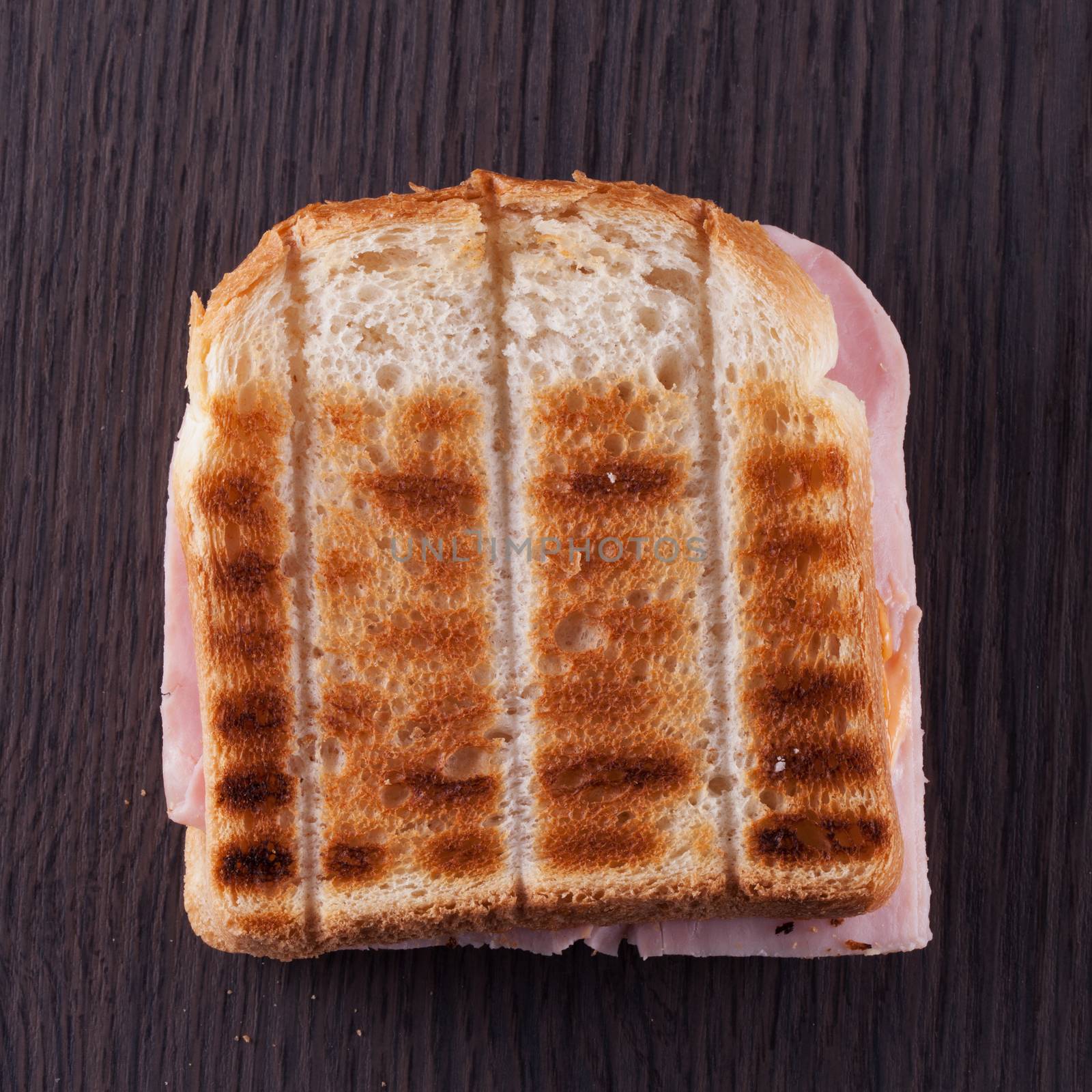 Toast with ham over dark wooden table