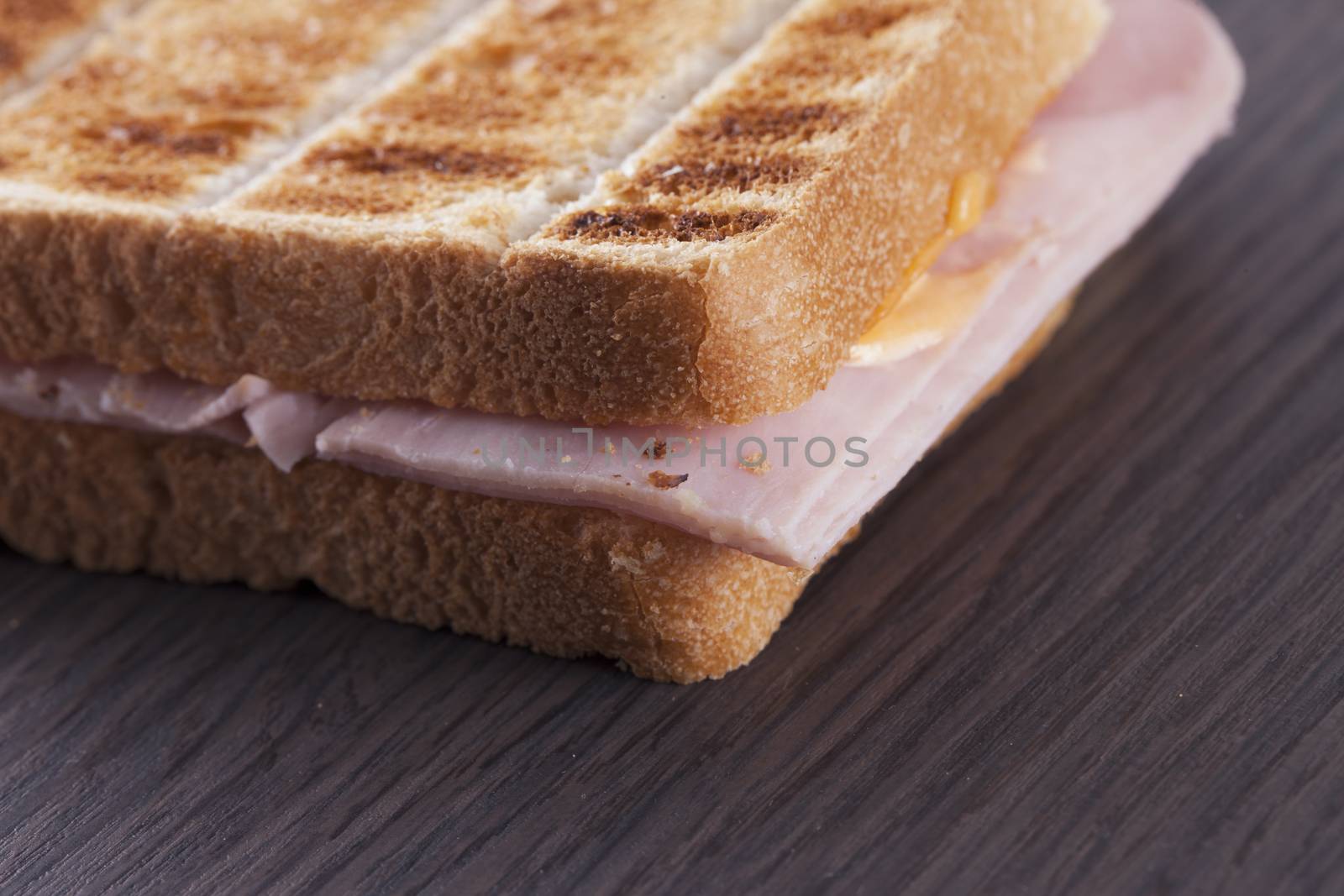 Toast with ham over dark wooden table