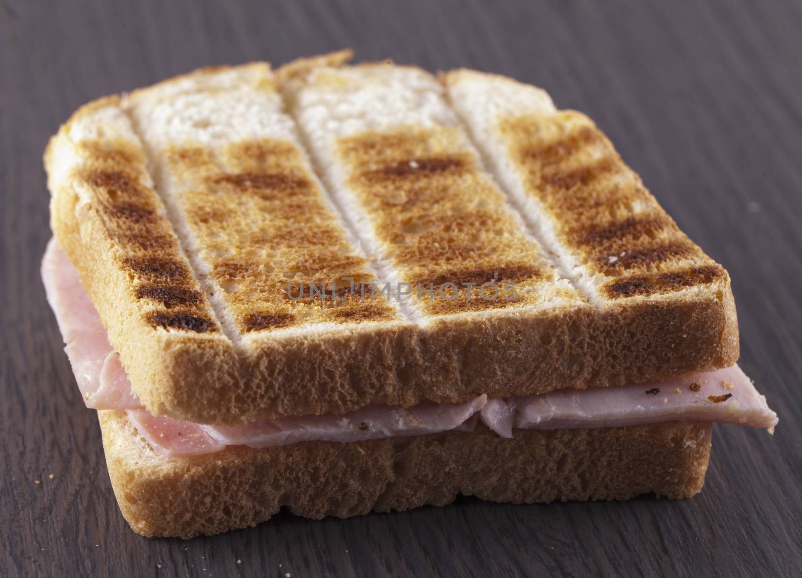 Toast with ham over dark wooden table