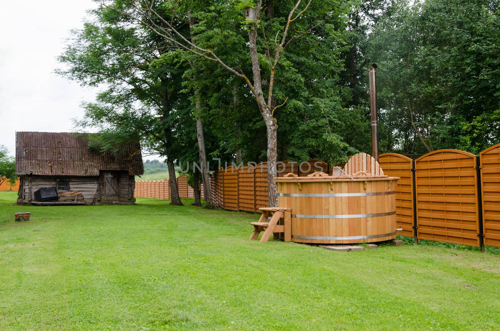 new modern wooden hot tub of water rural yard. outdoor bathhouse pleasure.