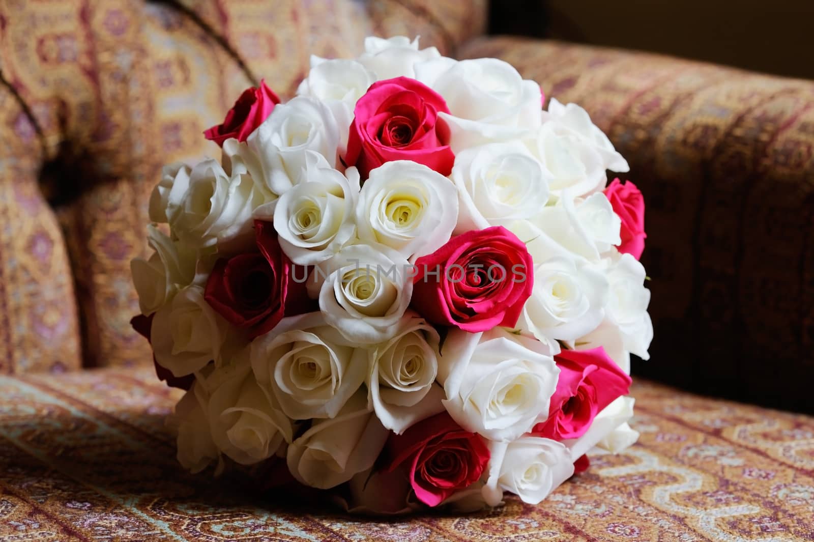 Brides red and white bouquet of roses closeup on wedding day