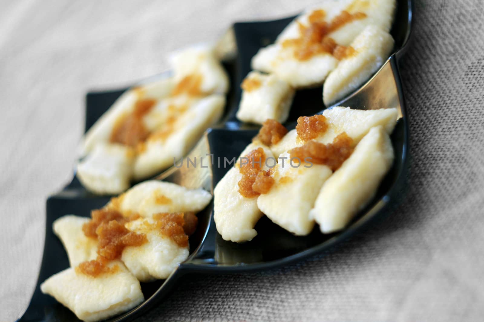 Cooked traditional lazy noodles with crumbs on black plate