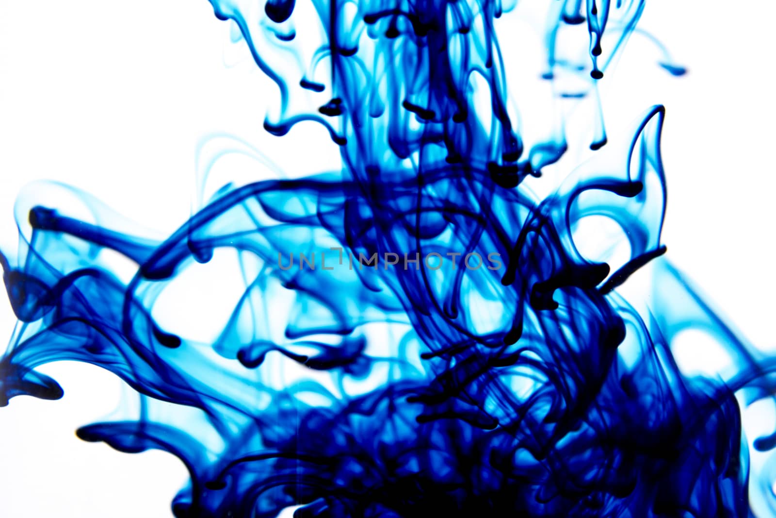 Vegetable ink poured into water with white background.