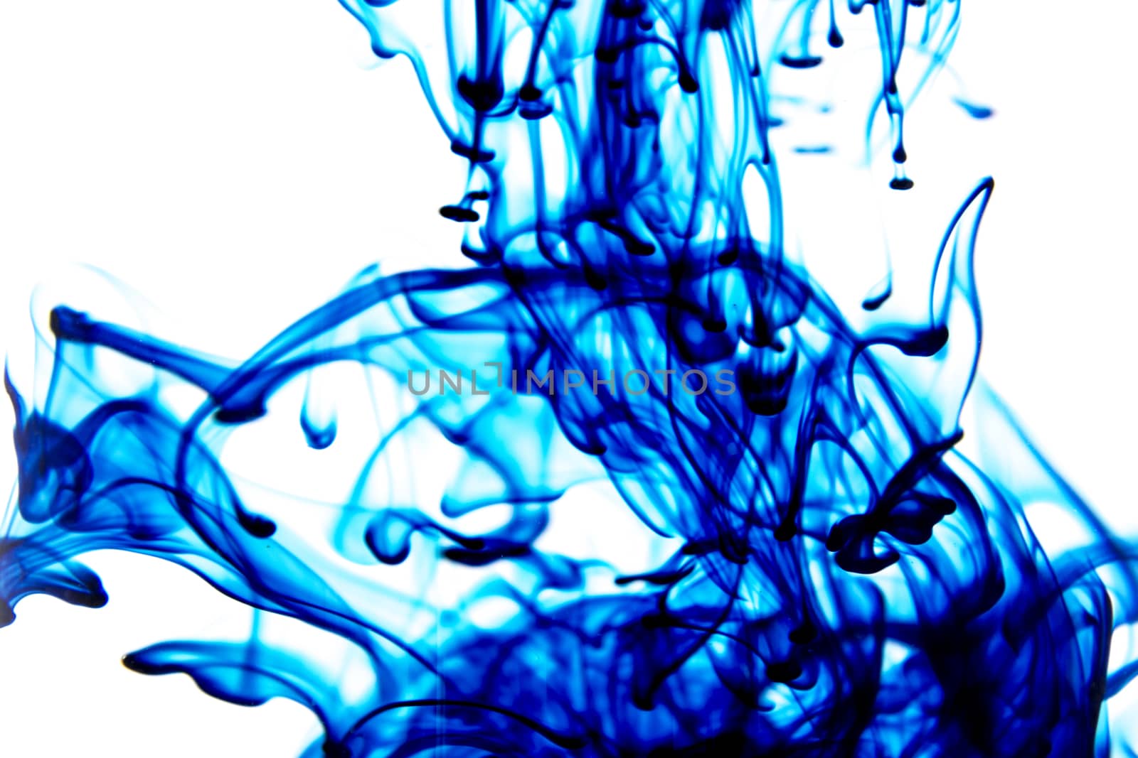 Vegetable ink poured into water with white background.