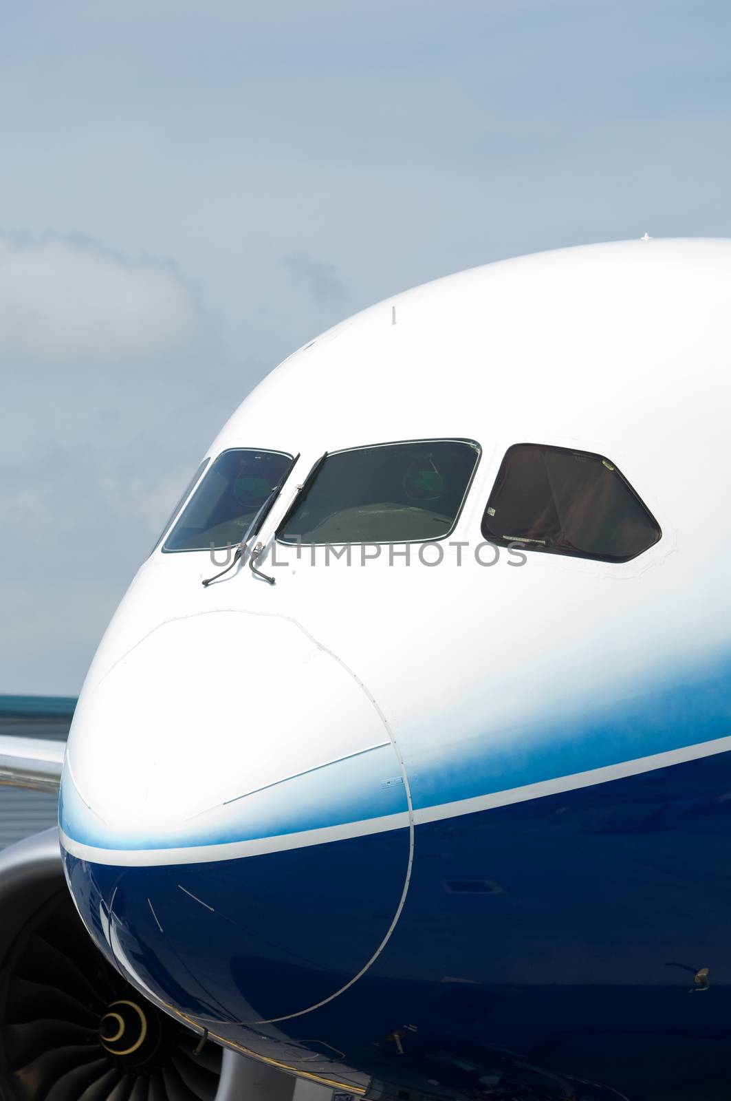 Front with cockpit windows of wide-body airplane.