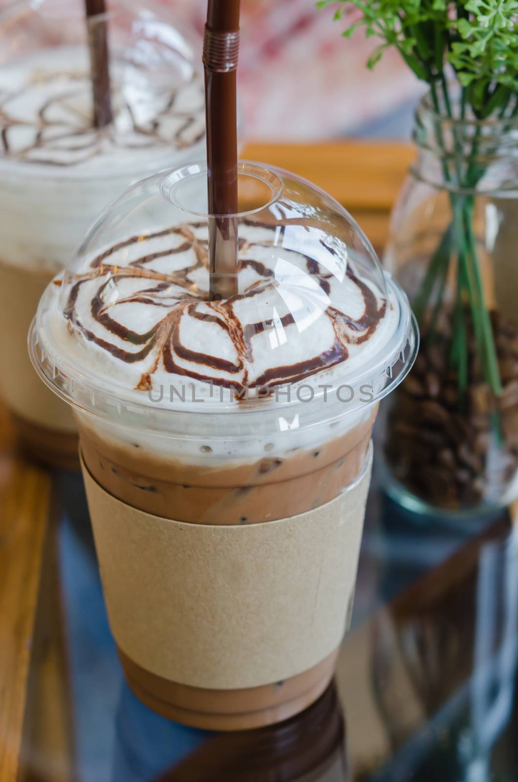 Iced coffee with straw in plastic cup