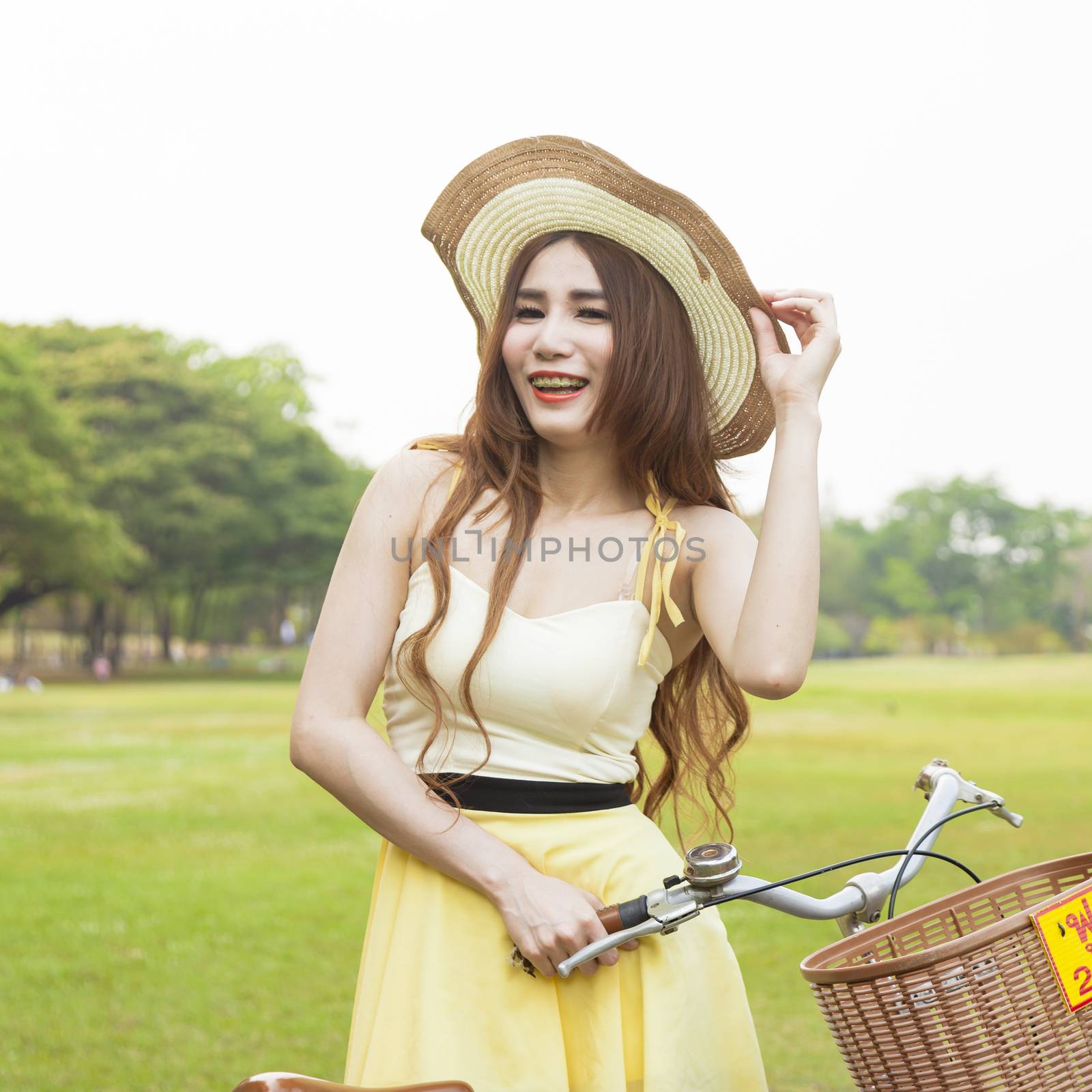 Woman with bike on the lawn. In the park on the lawn. With shady trees and natural