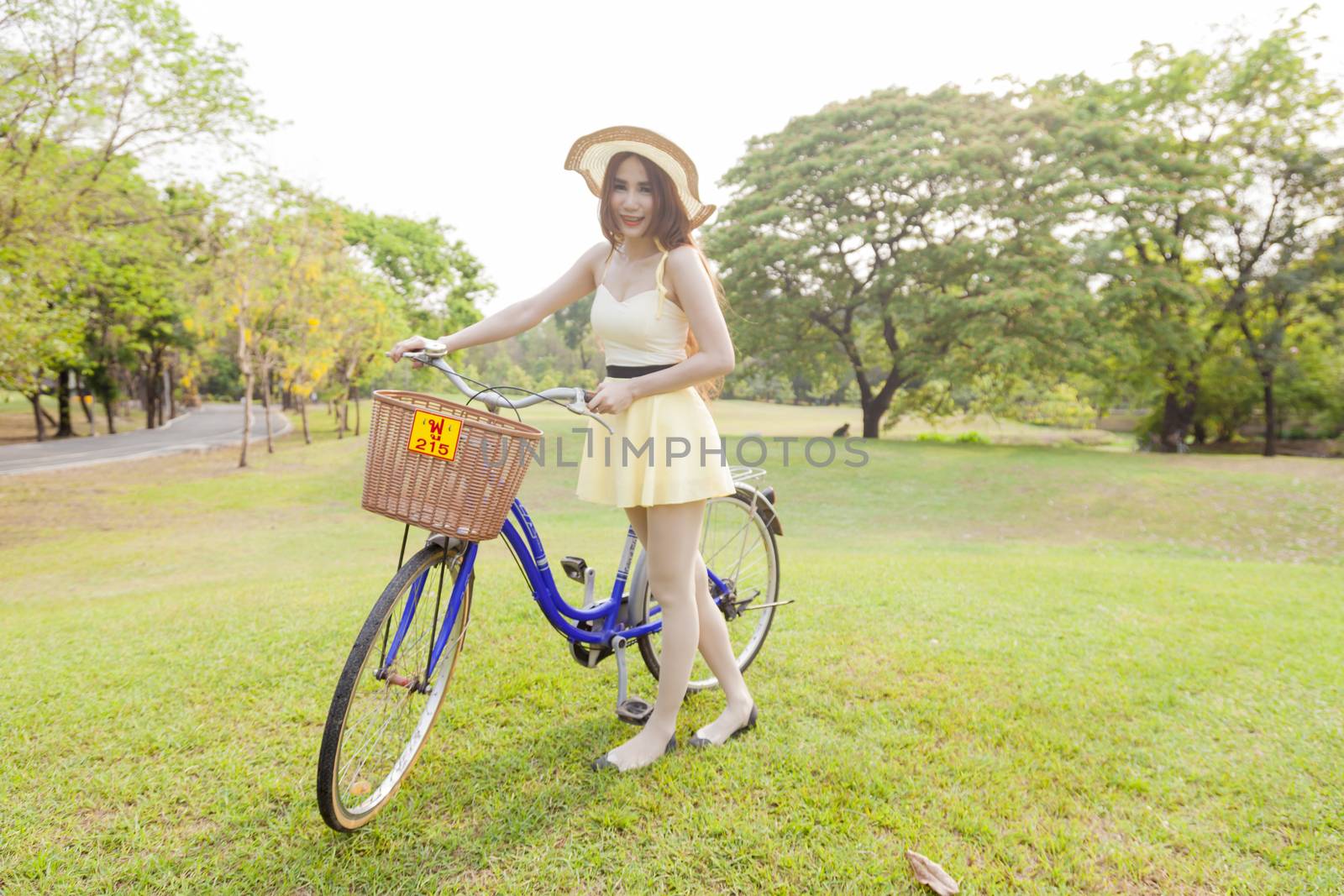 Asian woman and bikes. On the grass in the park.