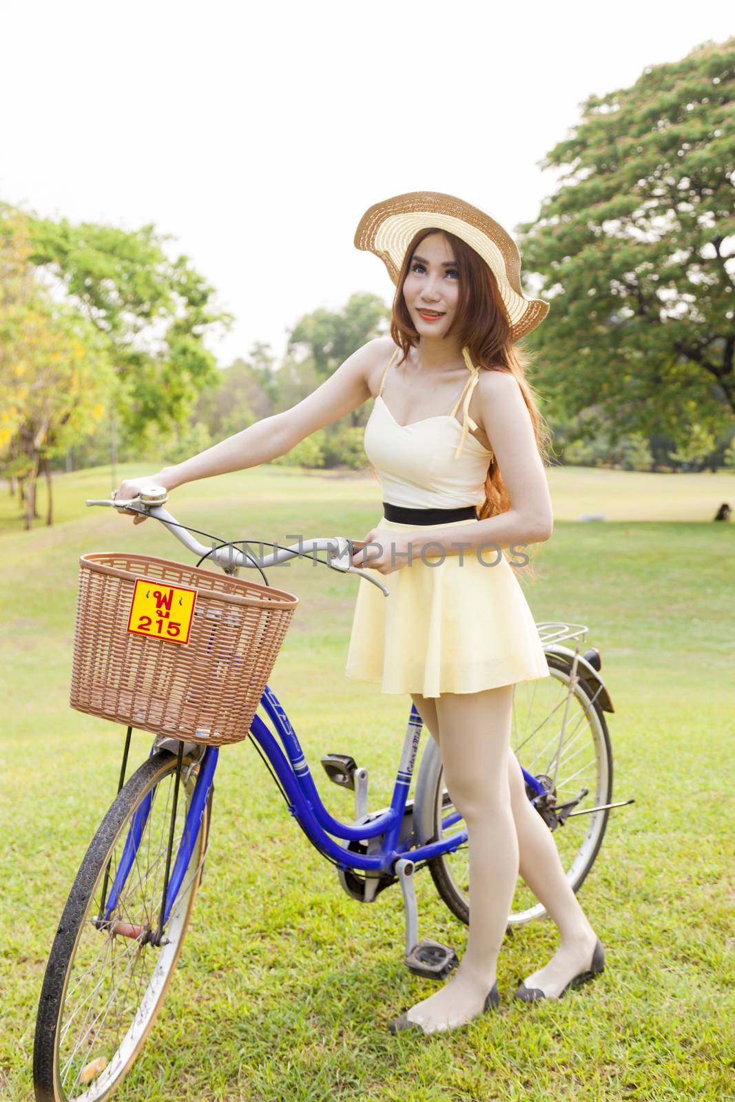 Asian woman and bikes. On the grass in the park.