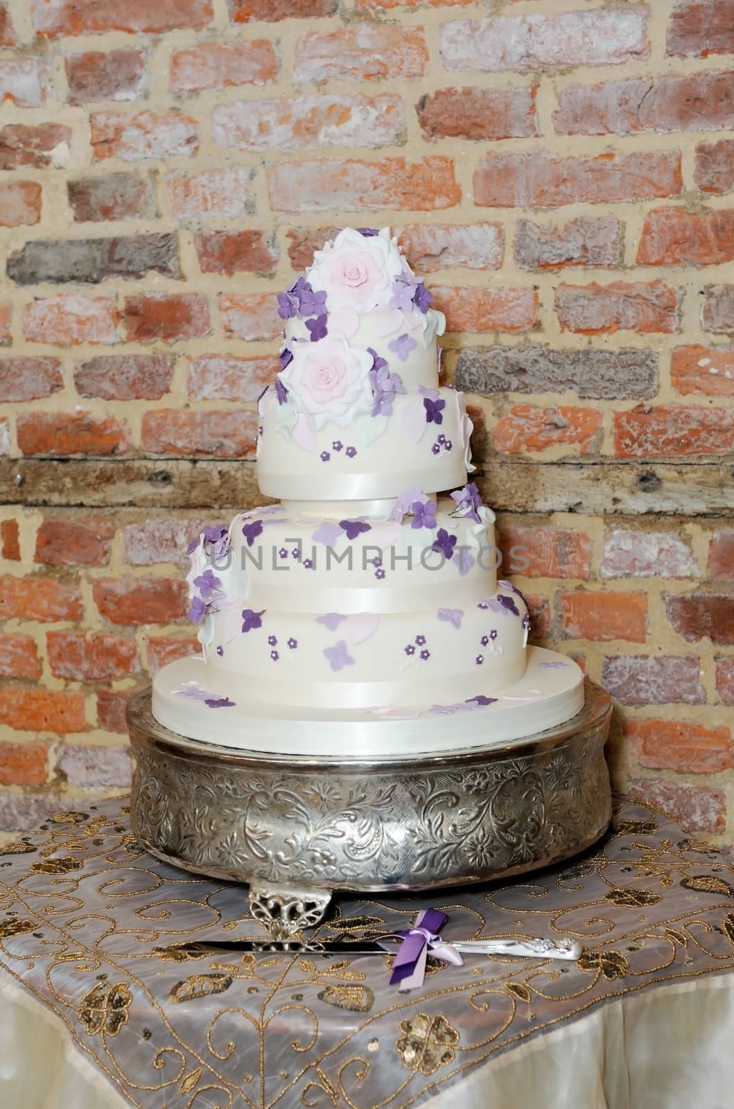 Wedding cake at reception with silver knife showing purple and pink decoration