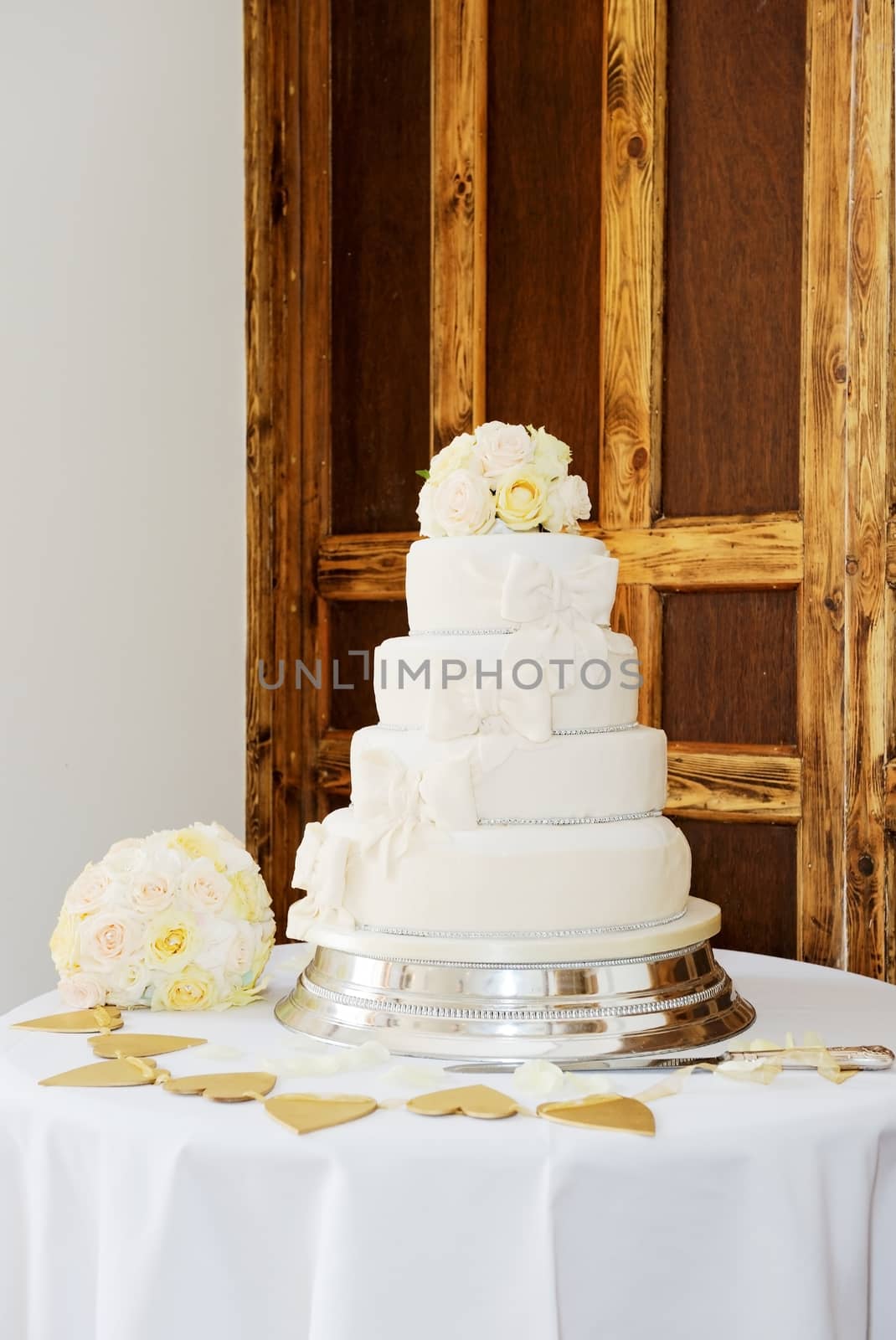 Wedding cake and brides bouquet of flowers at reception