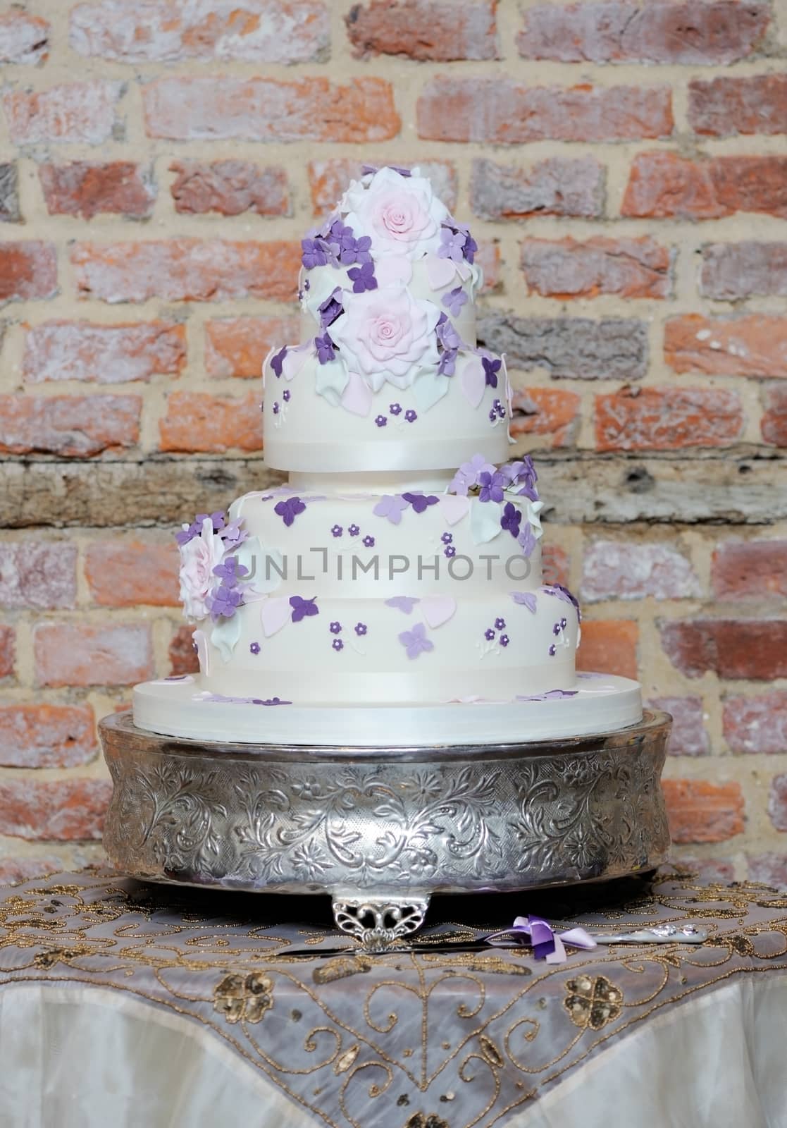 Wedding cake showing delicate pink and purple flower detail at reception