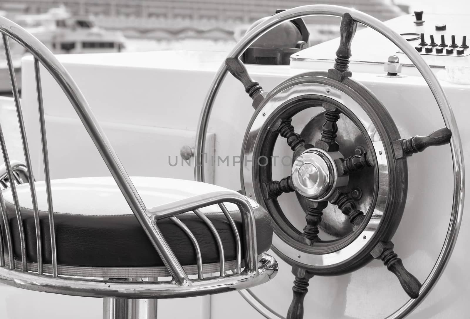 Closeup of rudder and chair in a luxury boat in black and white.