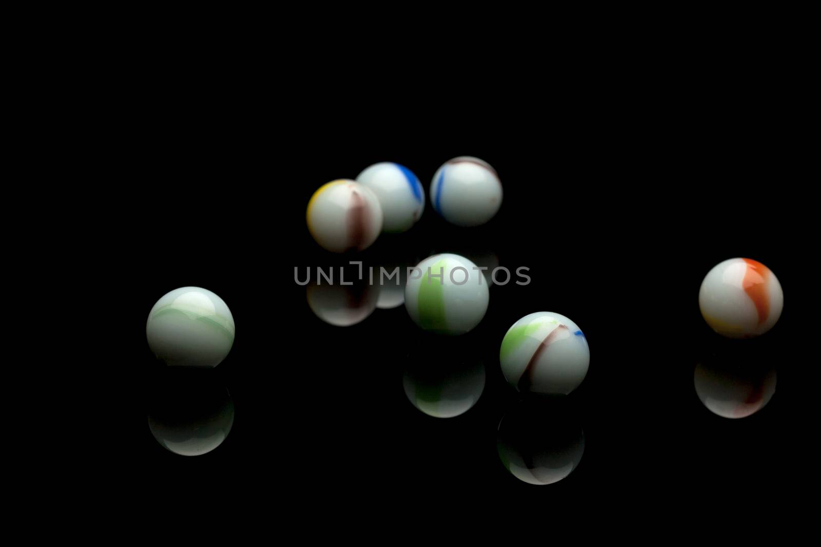 photo of color marbles on black with reflection