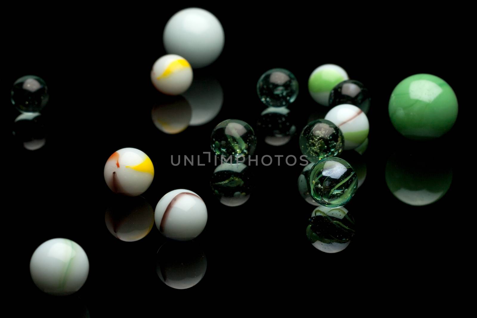 photo of color marbles on black with reflection