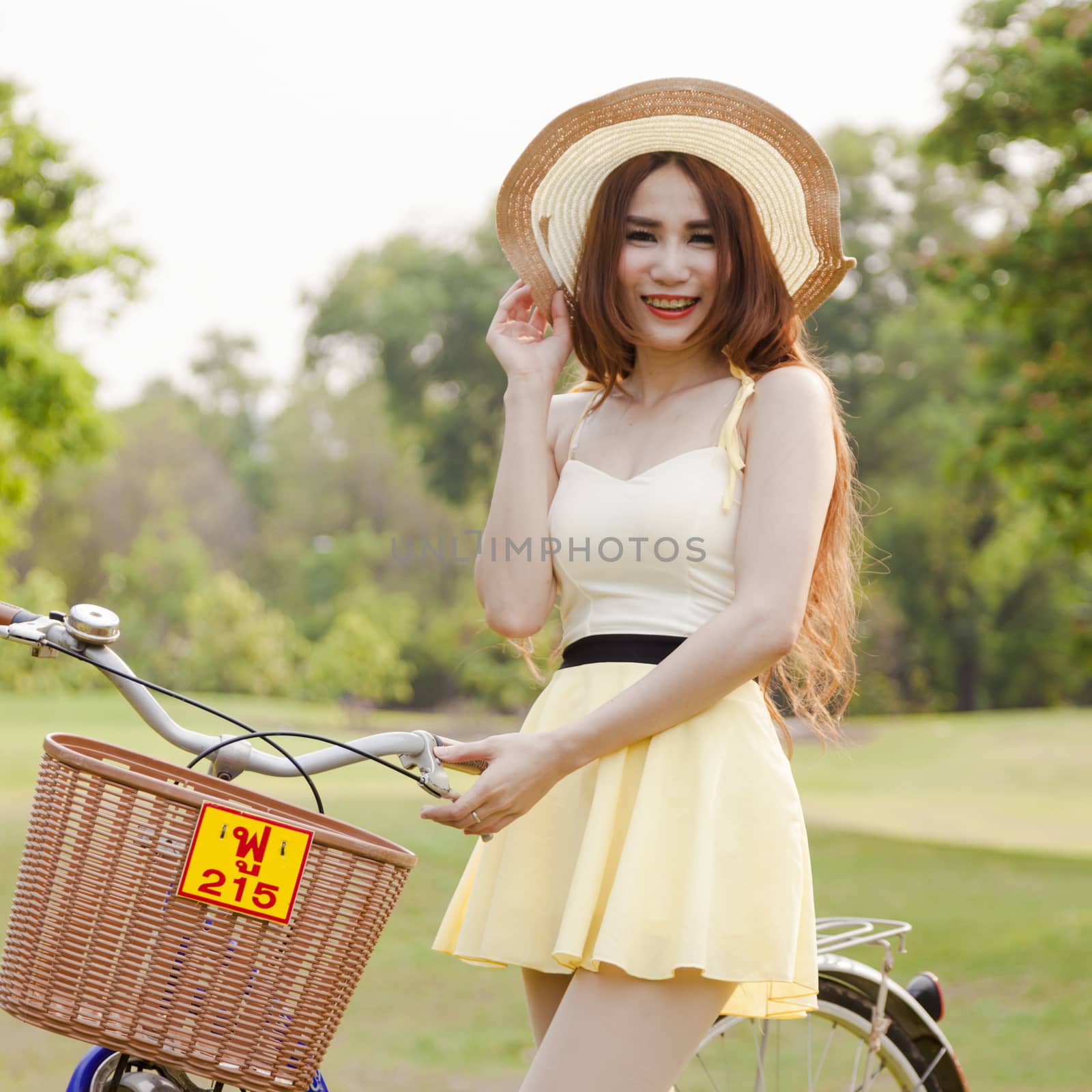 Asian woman and bikes. On the grass in the park.