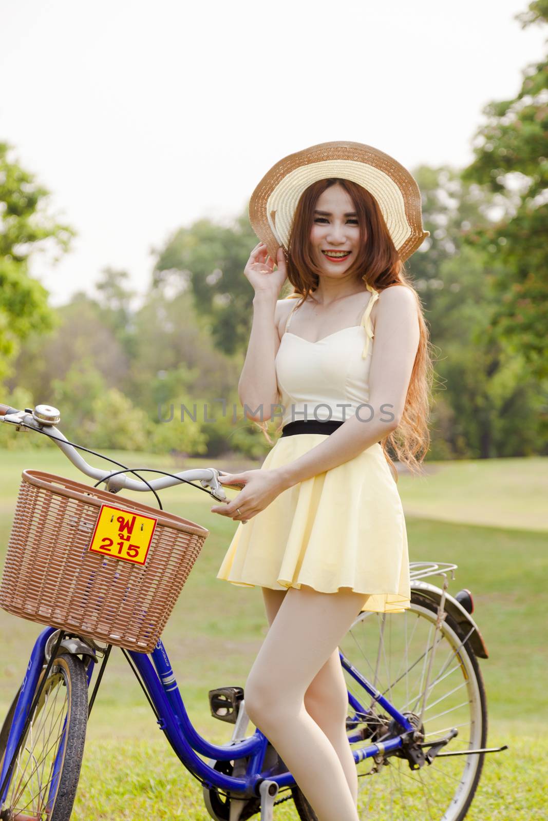 Asian woman and bikes. On the grass in the park.