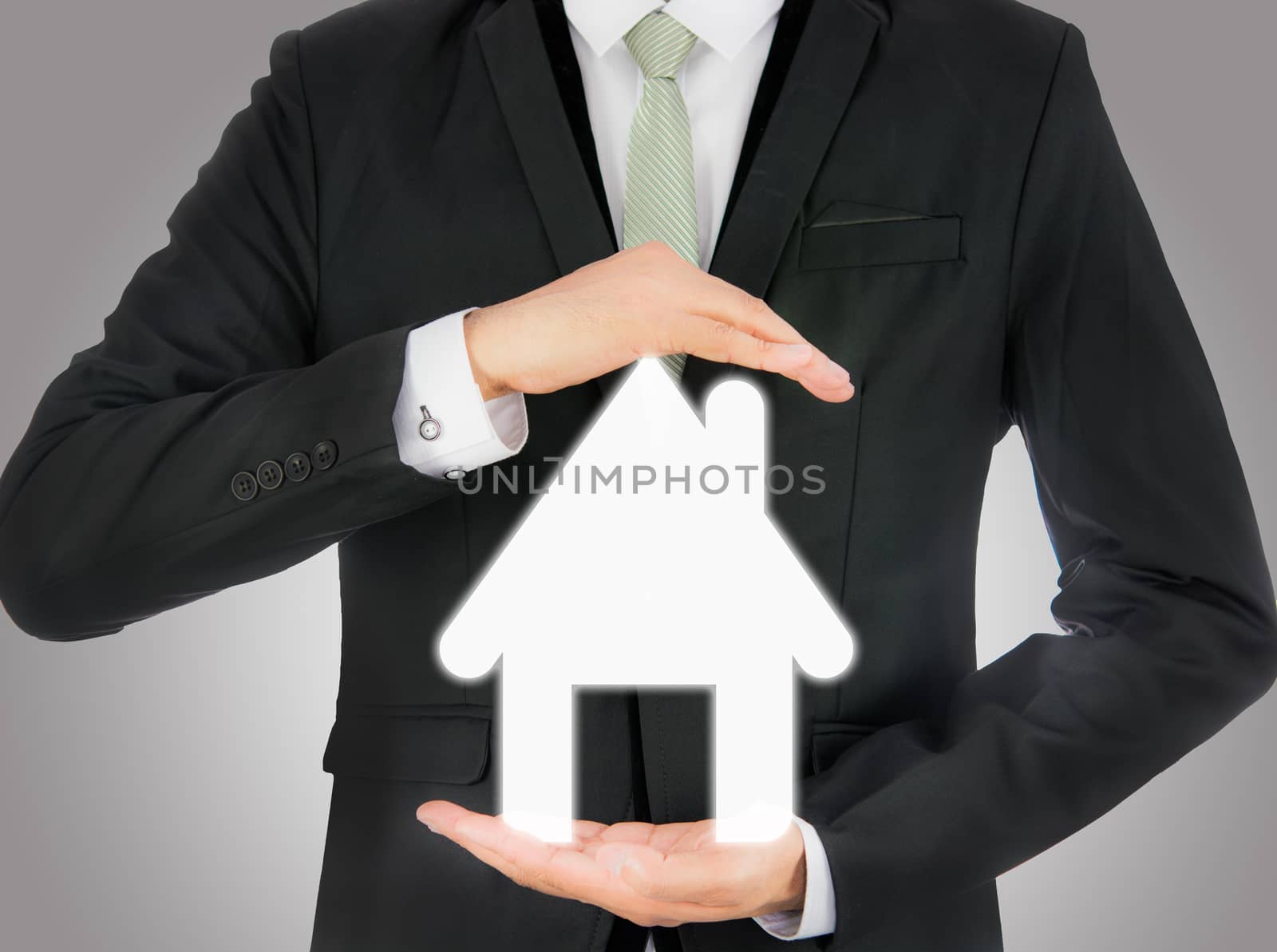 Businessman standing posture hand holding house icon isolated by Sorapop