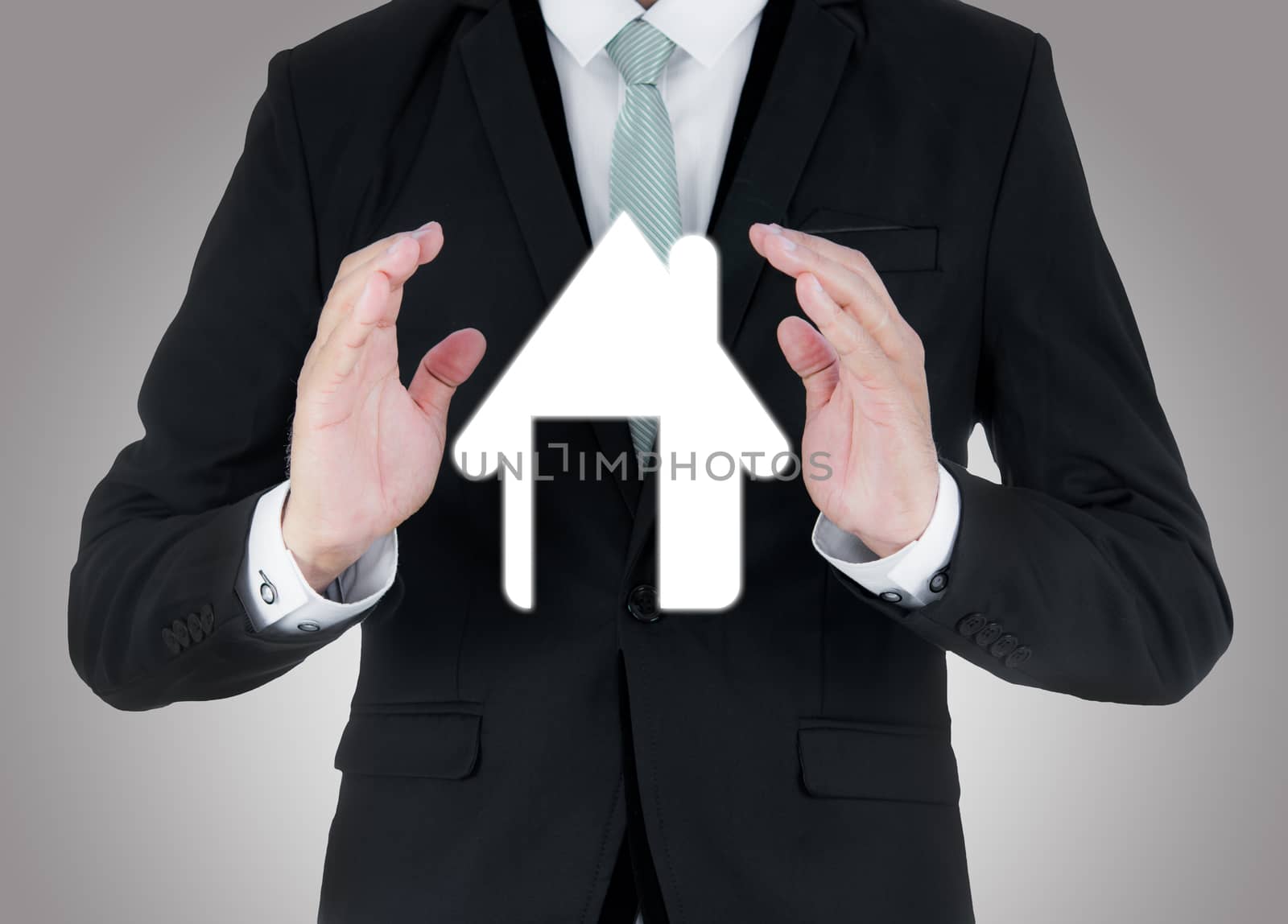 Businessman standing posture hand holding house icon isolated by Sorapop