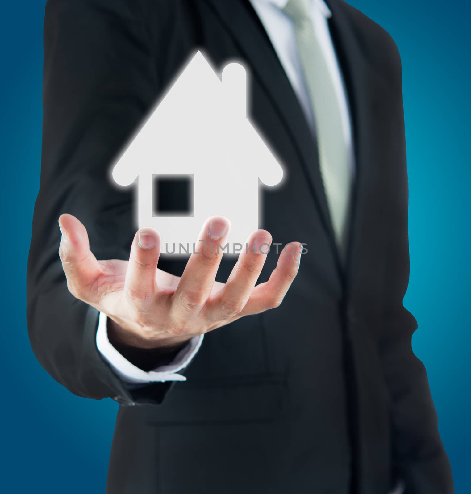 Businessman standing posture hand holding house icon isolated on over blue background