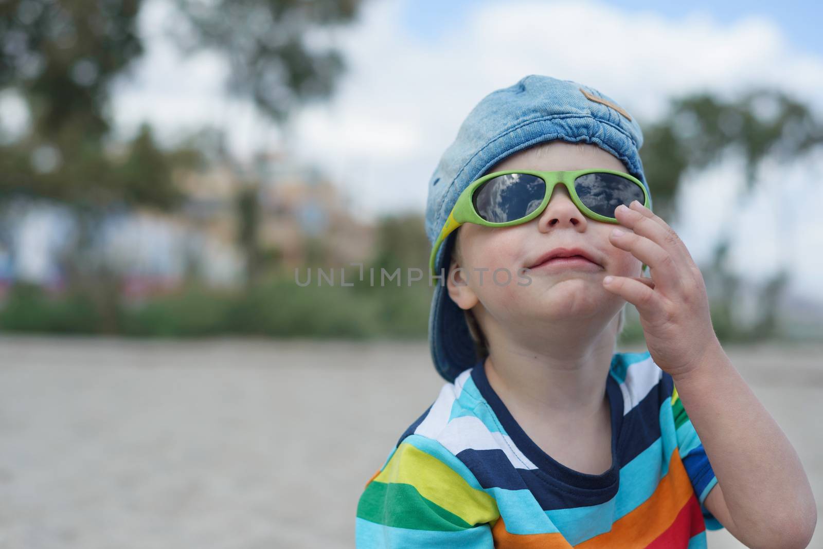 Cute small boy in denim hat and sunglasses