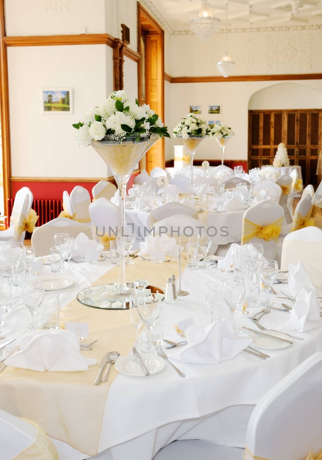 Floral arrangements decorate wedding reception with white flowers in glass on tables