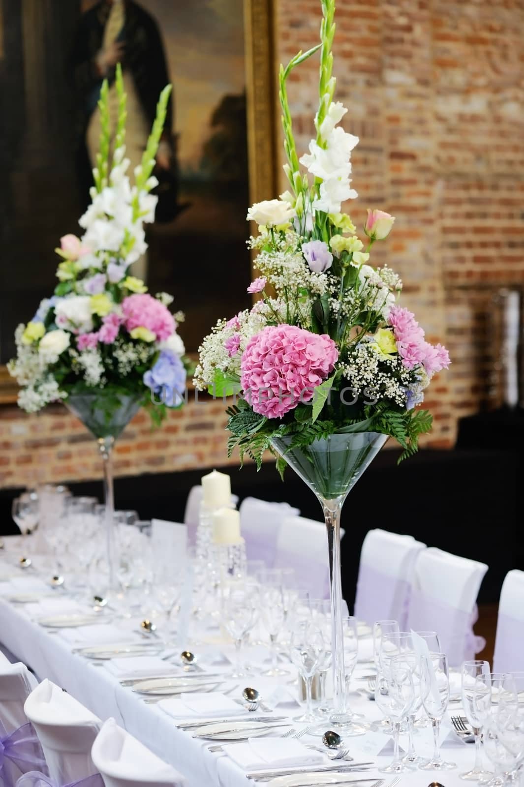 Floral arrangement at wedding reception with pink, purple and white flowers