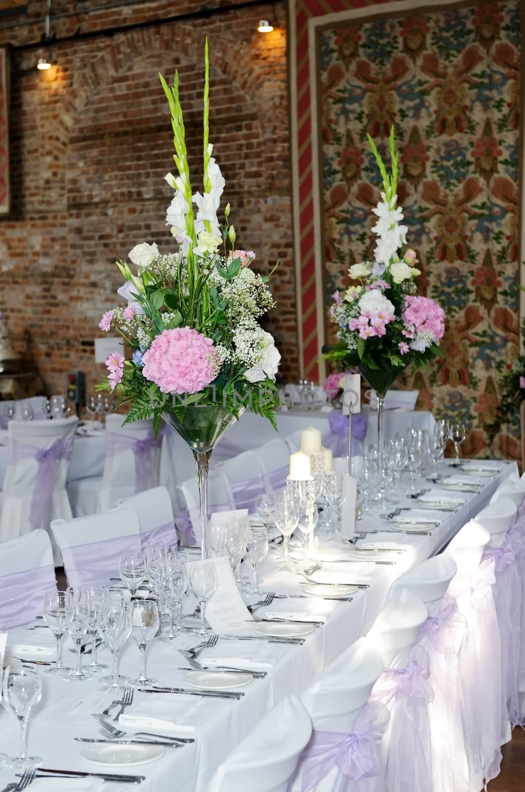 Wedding reception setting shows table with floral arrangements