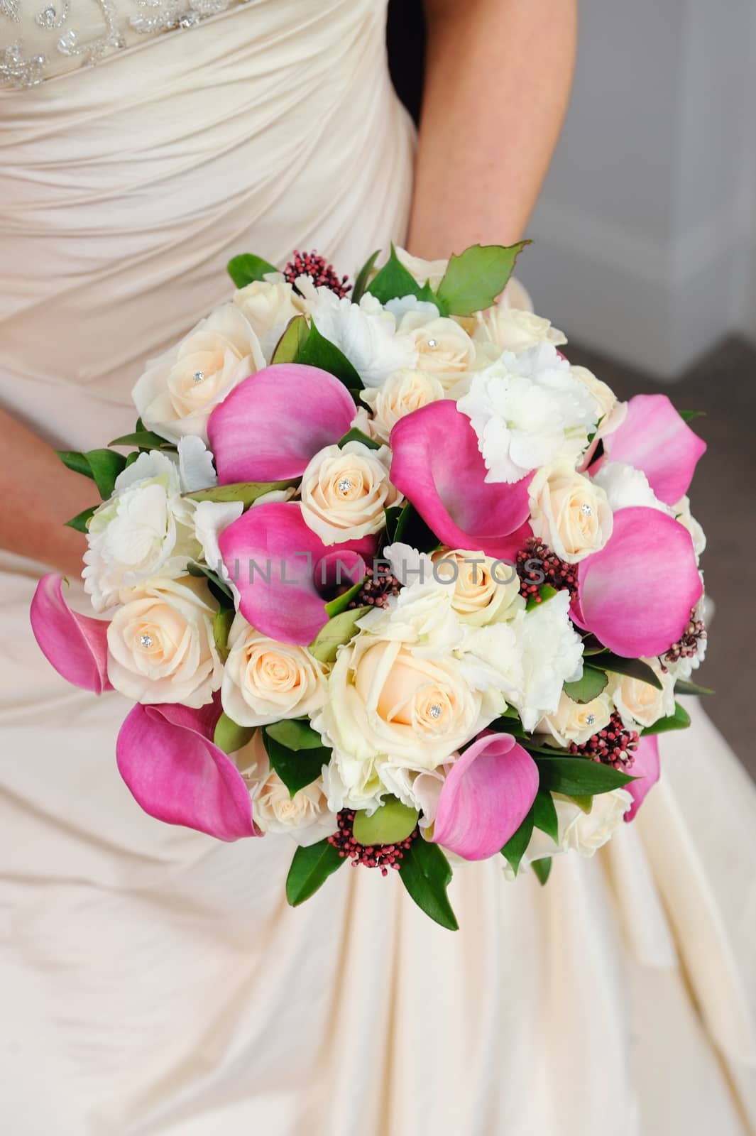 Bride holds flowers. by kmwphotography