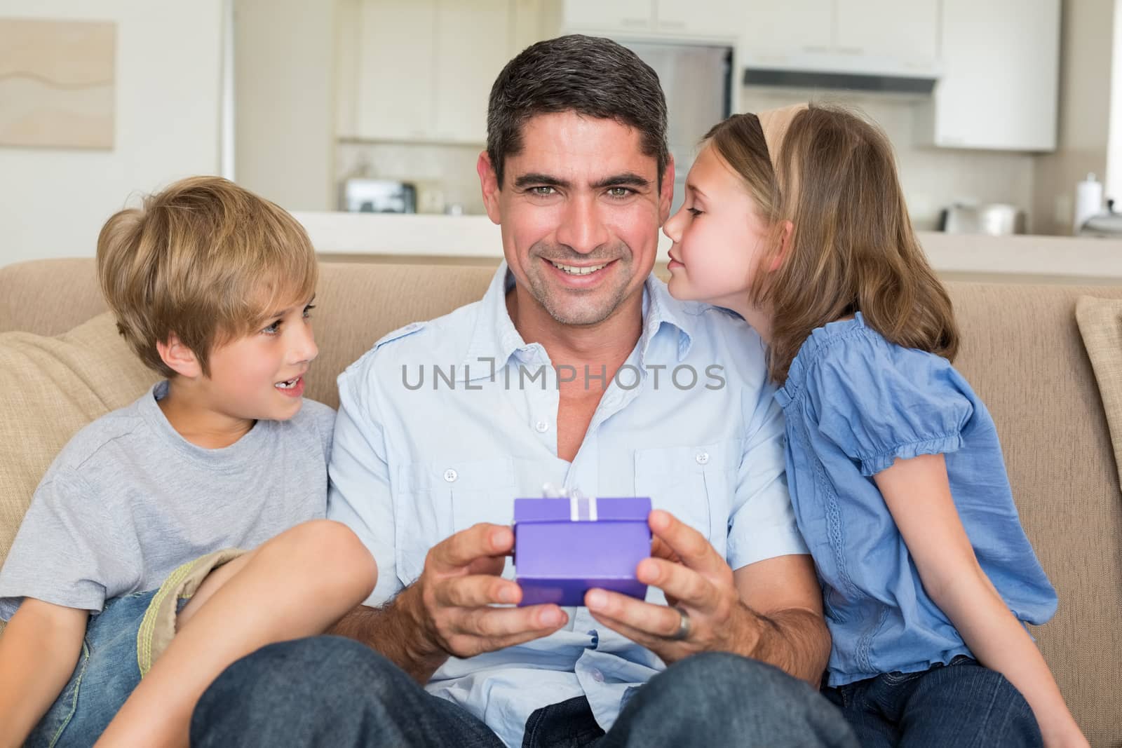 Father receiving gift from loving children by Wavebreakmedia