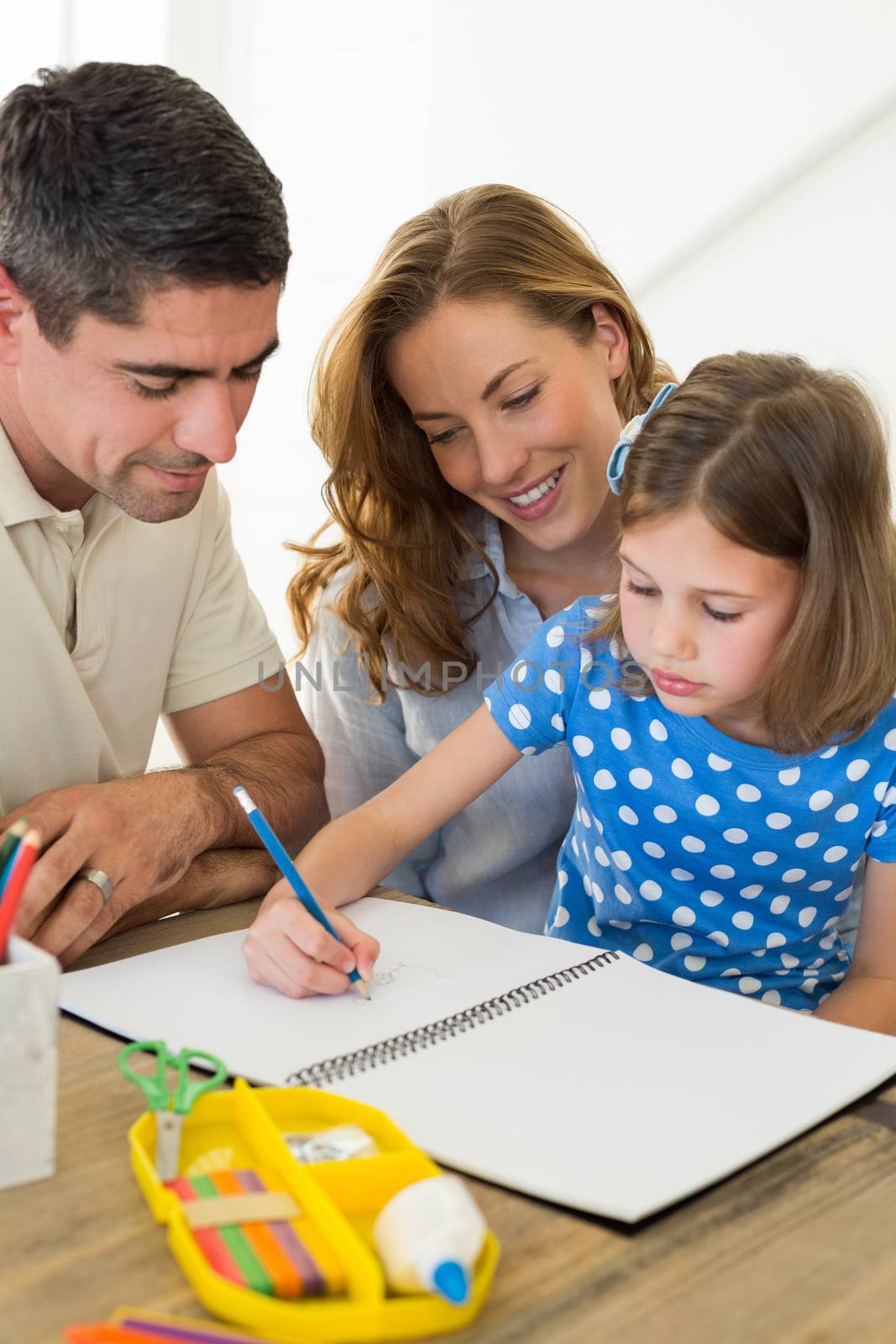 Parents assisting daughter in coloring at home 