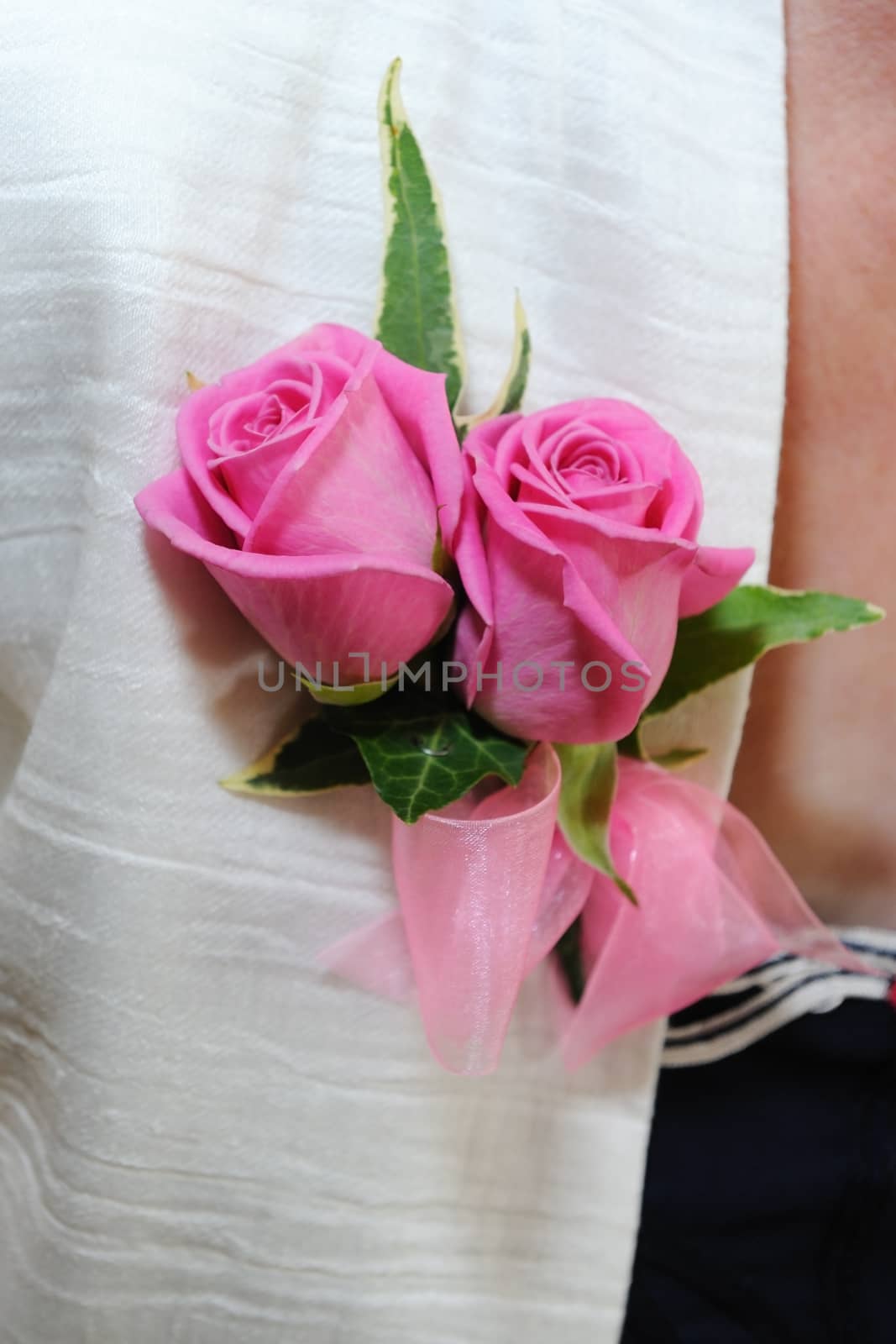 Mothers pink corsage on white jacket.