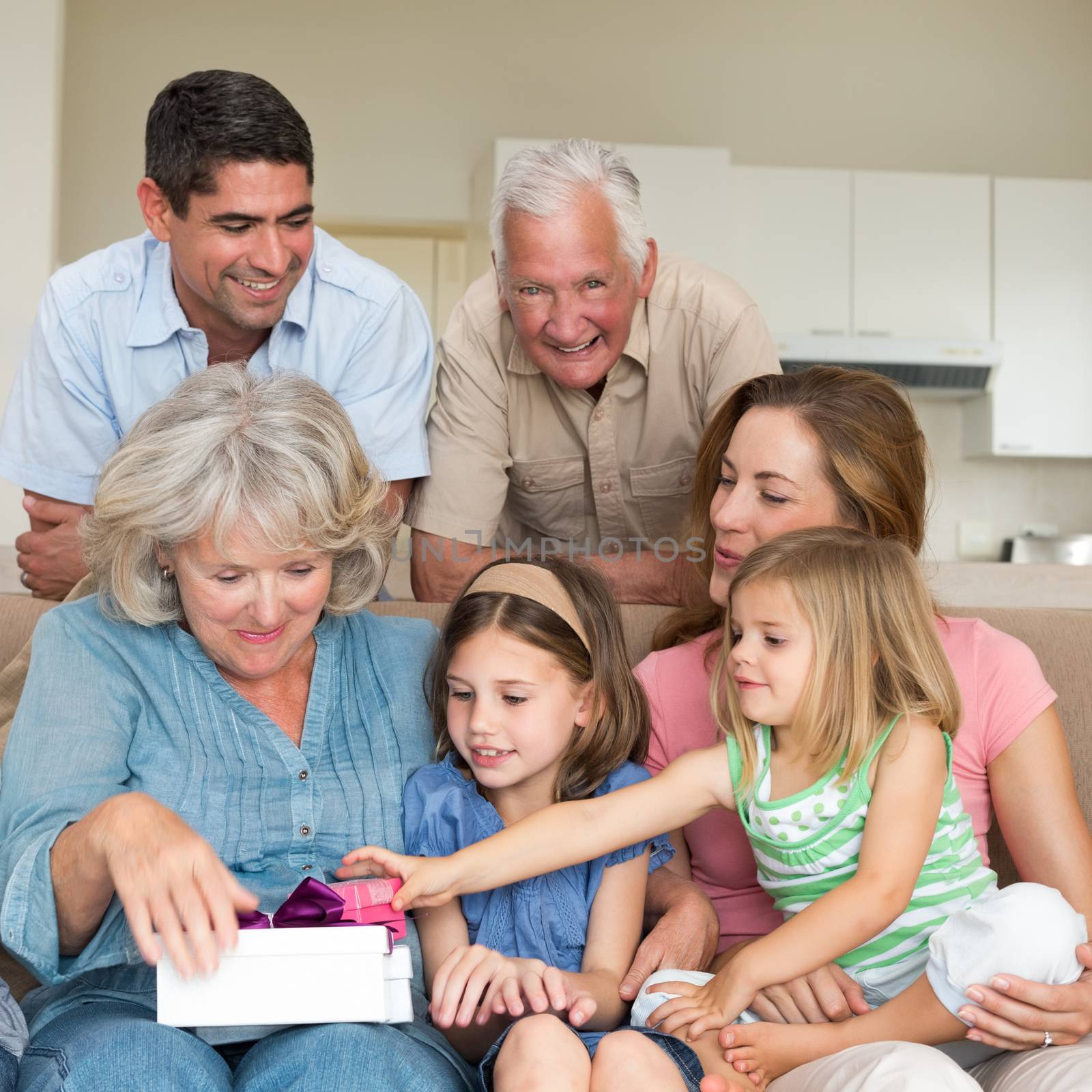 Smiling multigeneration family with gifts in sitting room