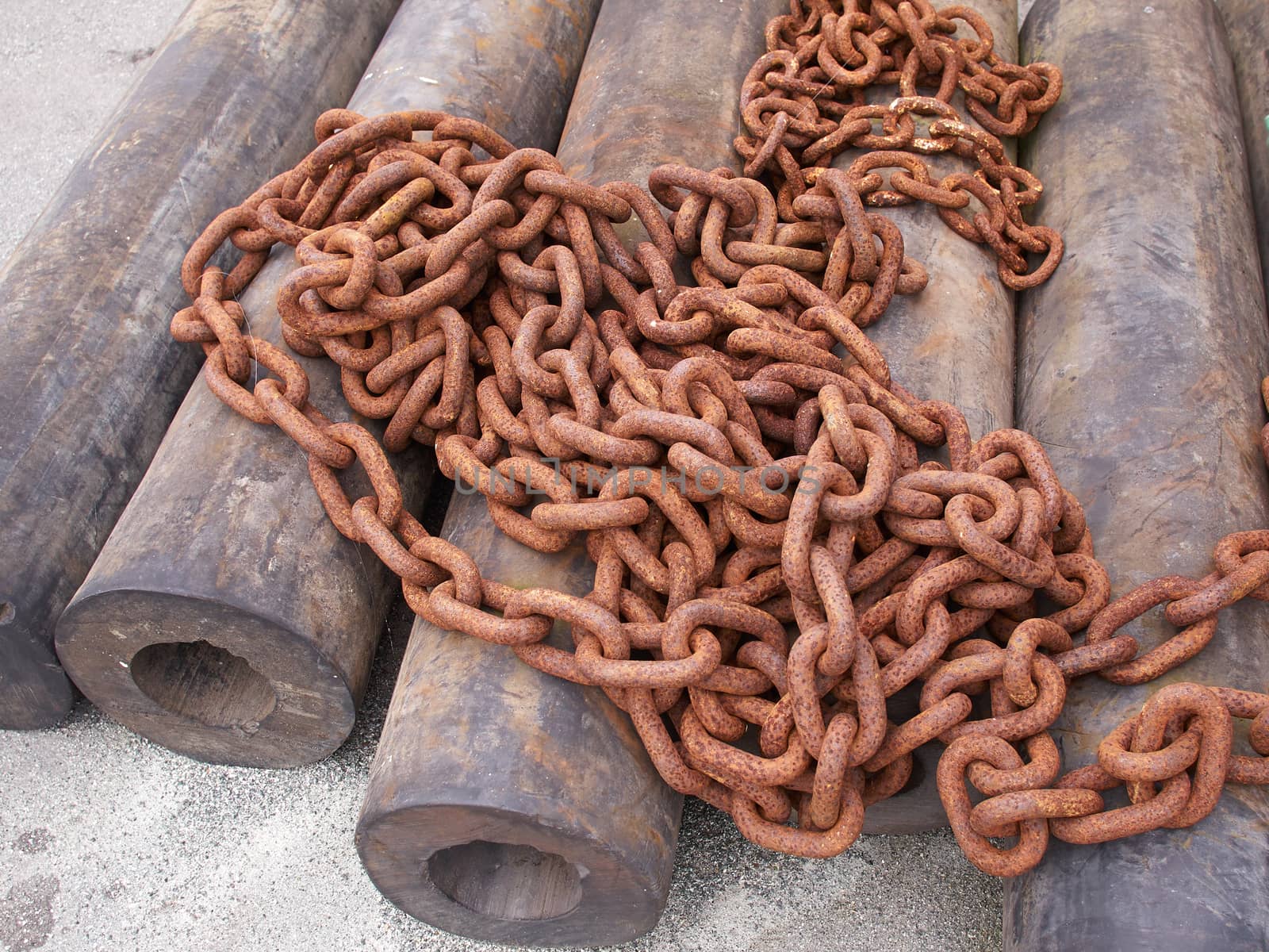 Rusty old iron chains on the ground in a port