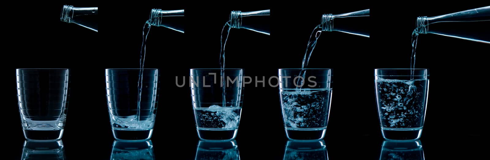 Pouring water on glass on over black background