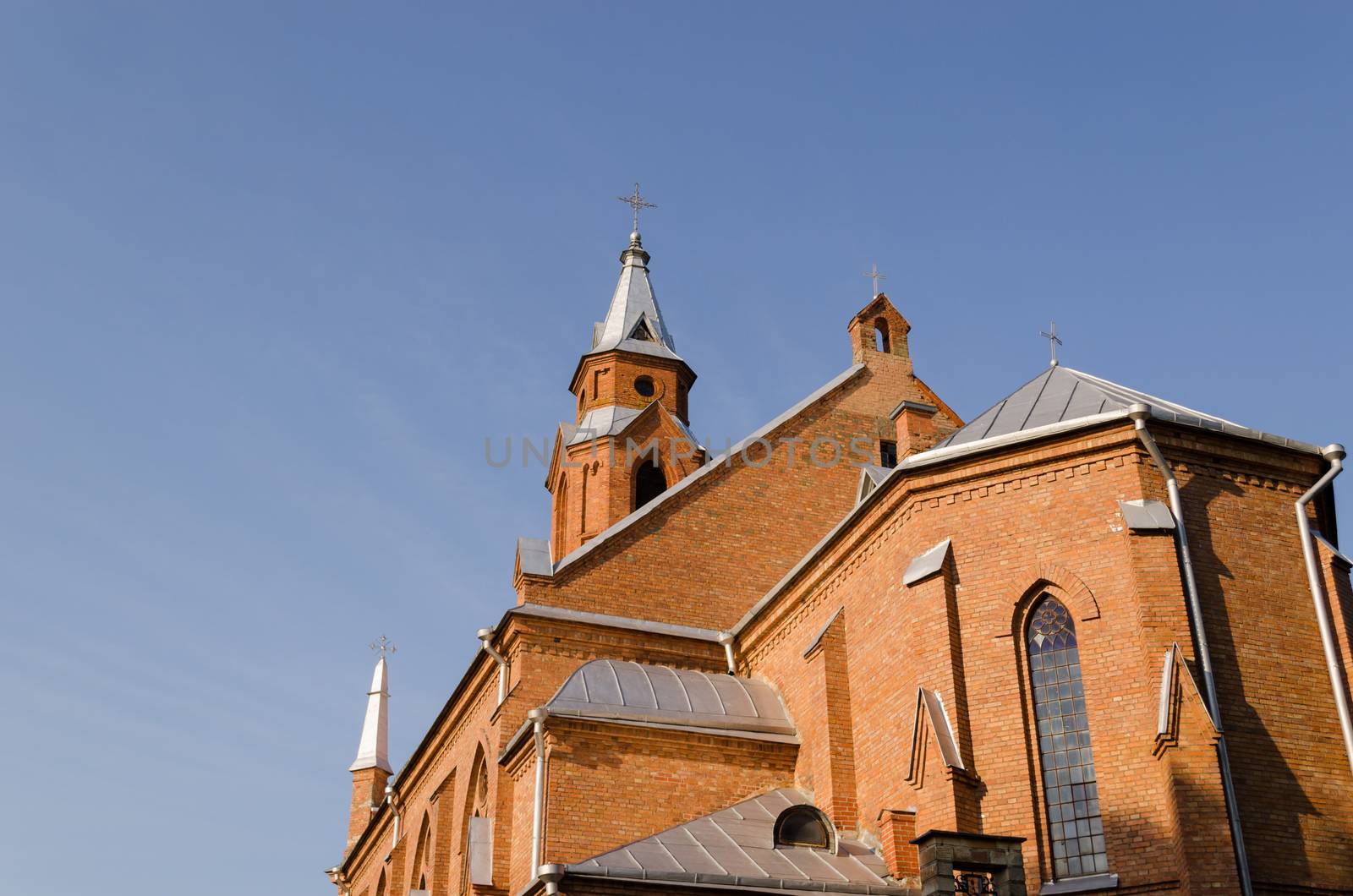 gothic church towers with crosses and small windows on blue sky background