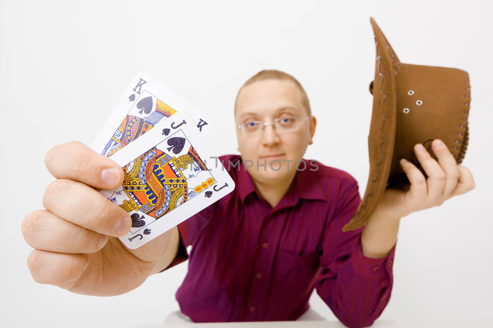 Man holding hat and two cards: the king and jack