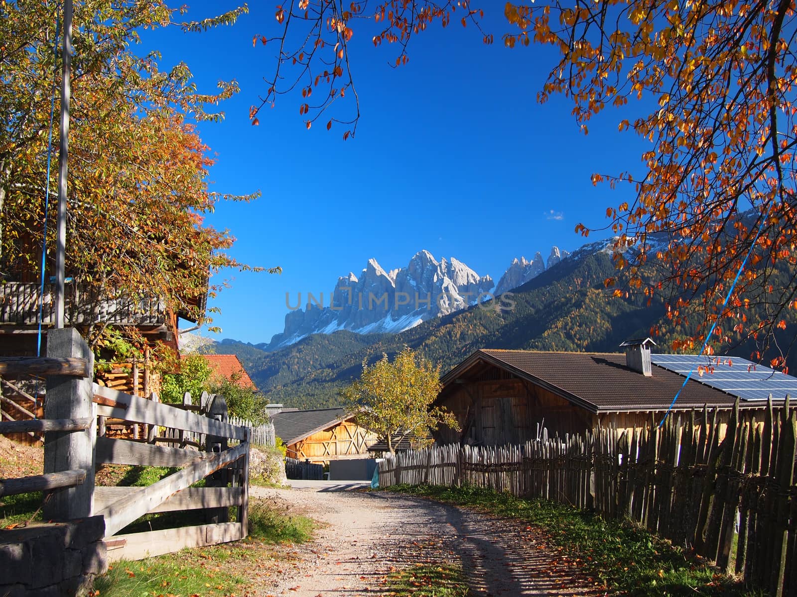 A rural village in the Funes Valley (Val di Funes) with in the background the Odle Dolomites mountain peaks in autumn in South Tyrol in Italy.