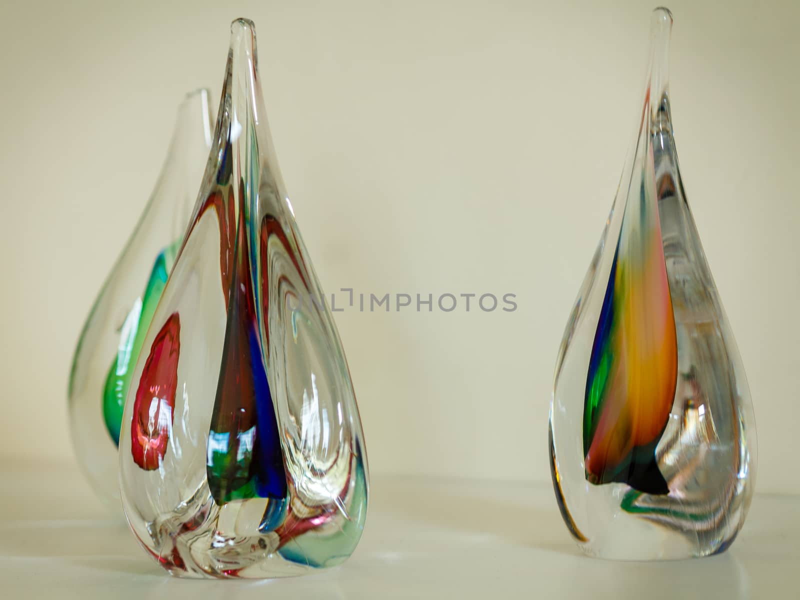 Three glass sculptures with various colors worked into them.