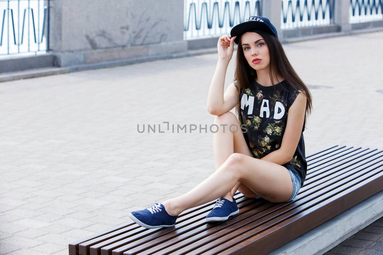 Street, outdoor. Attractive teen in a cap